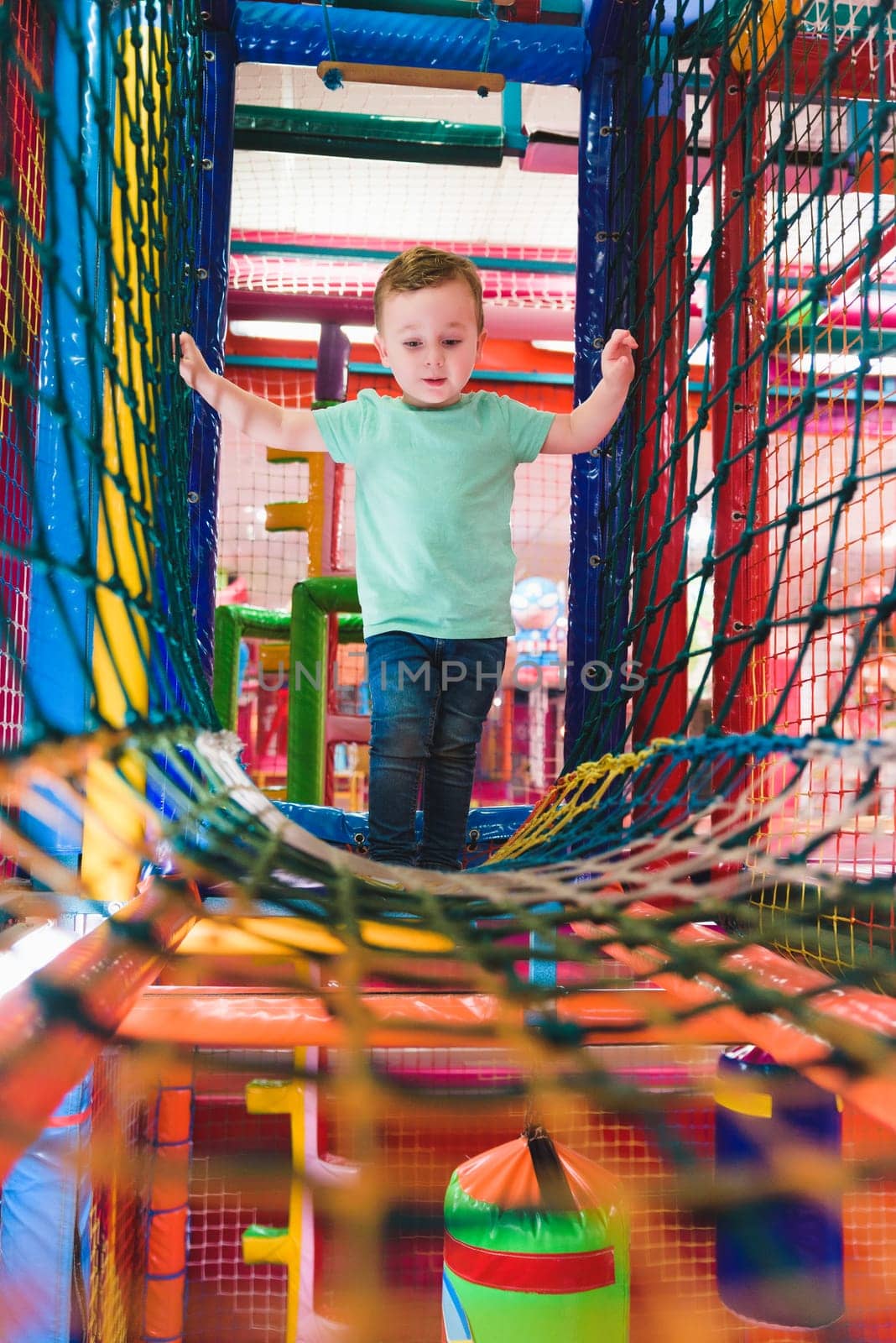 little boy playing inside a tunnel in the playground voting balls.