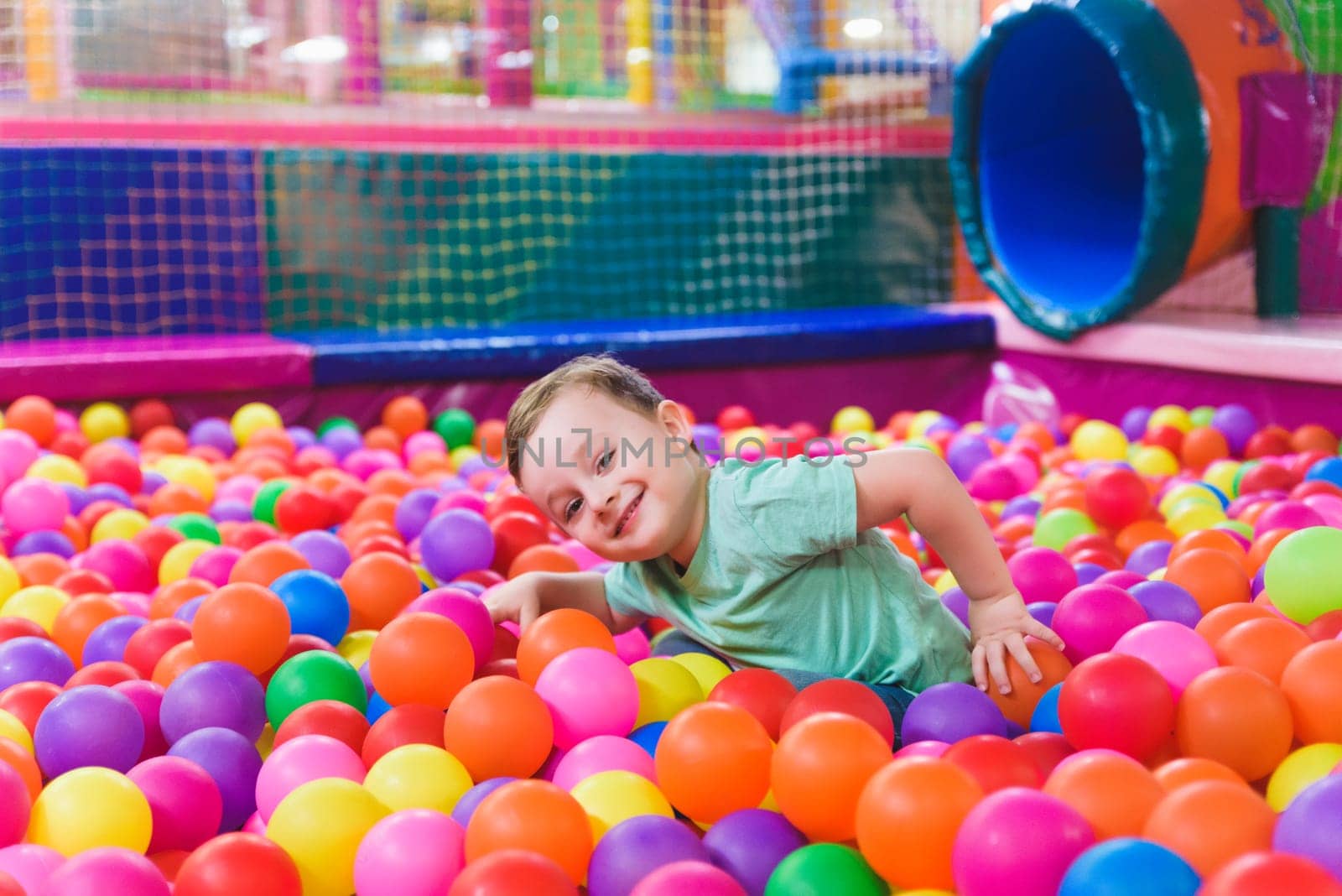 Portrait of three funny little kids playing in ball pit and enjoying time in childrens entertainment and play area, copy space by jcdiazhidalgo