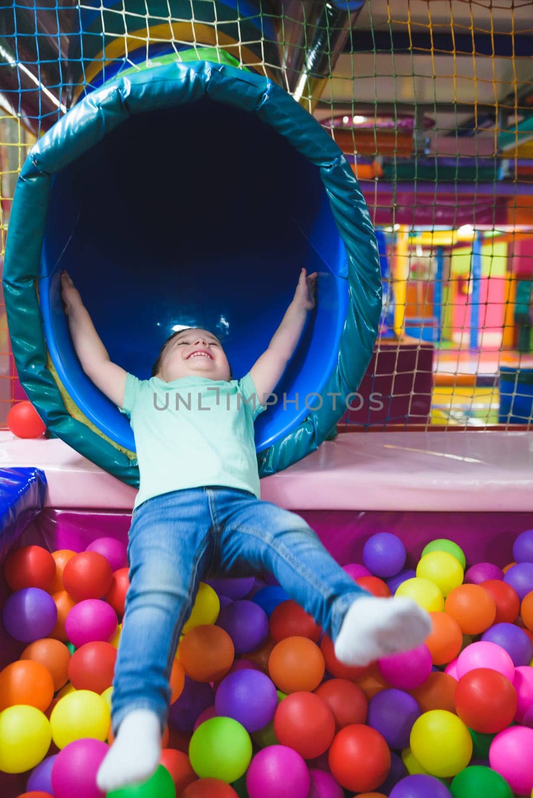 boy on the playground with colored plastic balls.