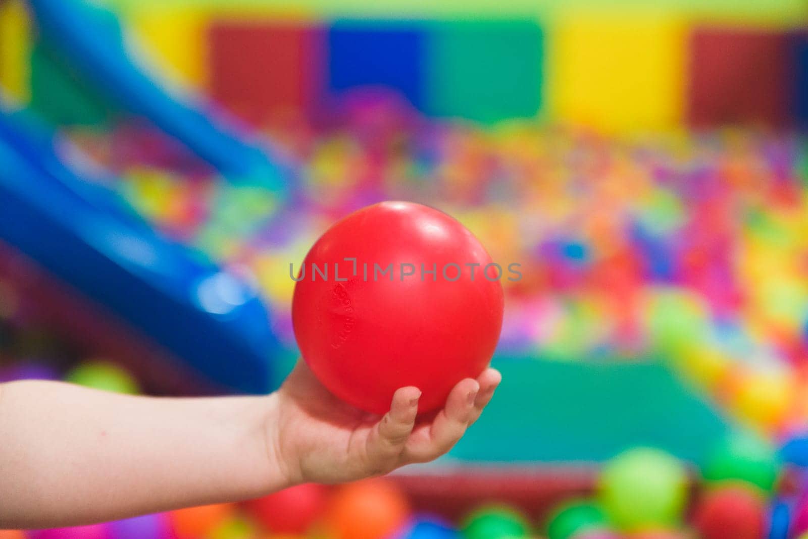 Creative development of children. The child plays with colored balls in the child development center.