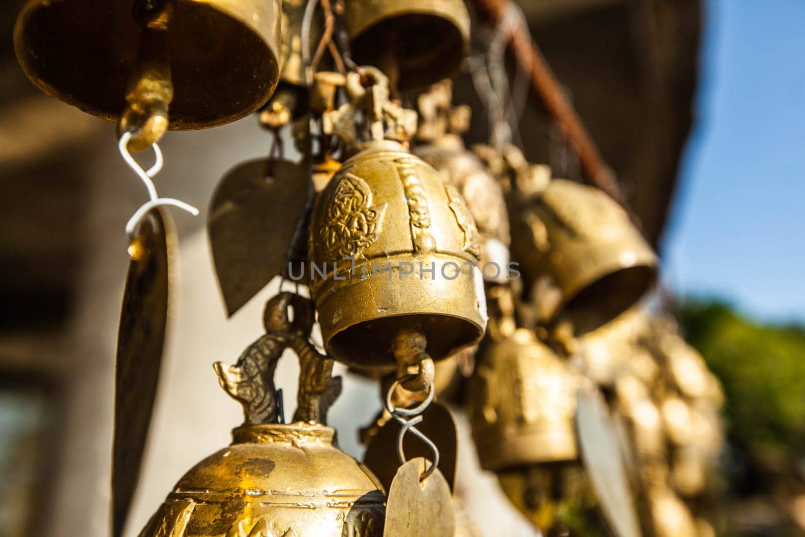 Many golden buddhist bells with wishes in sunlight