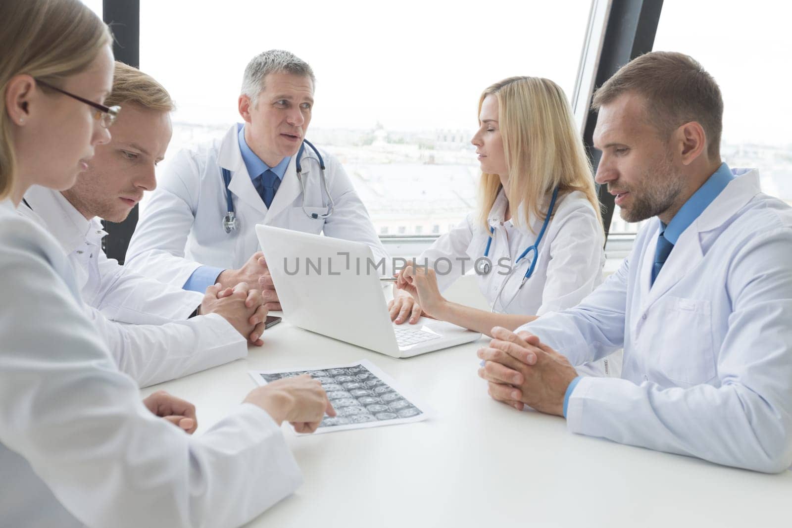 Group of doctors look and discuss x-ray in a clinic or hospital