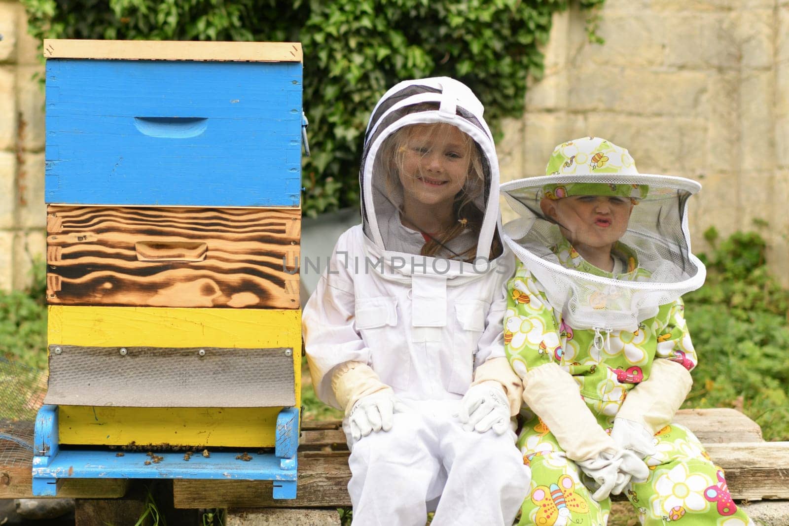 Children in protective suits at the beehive