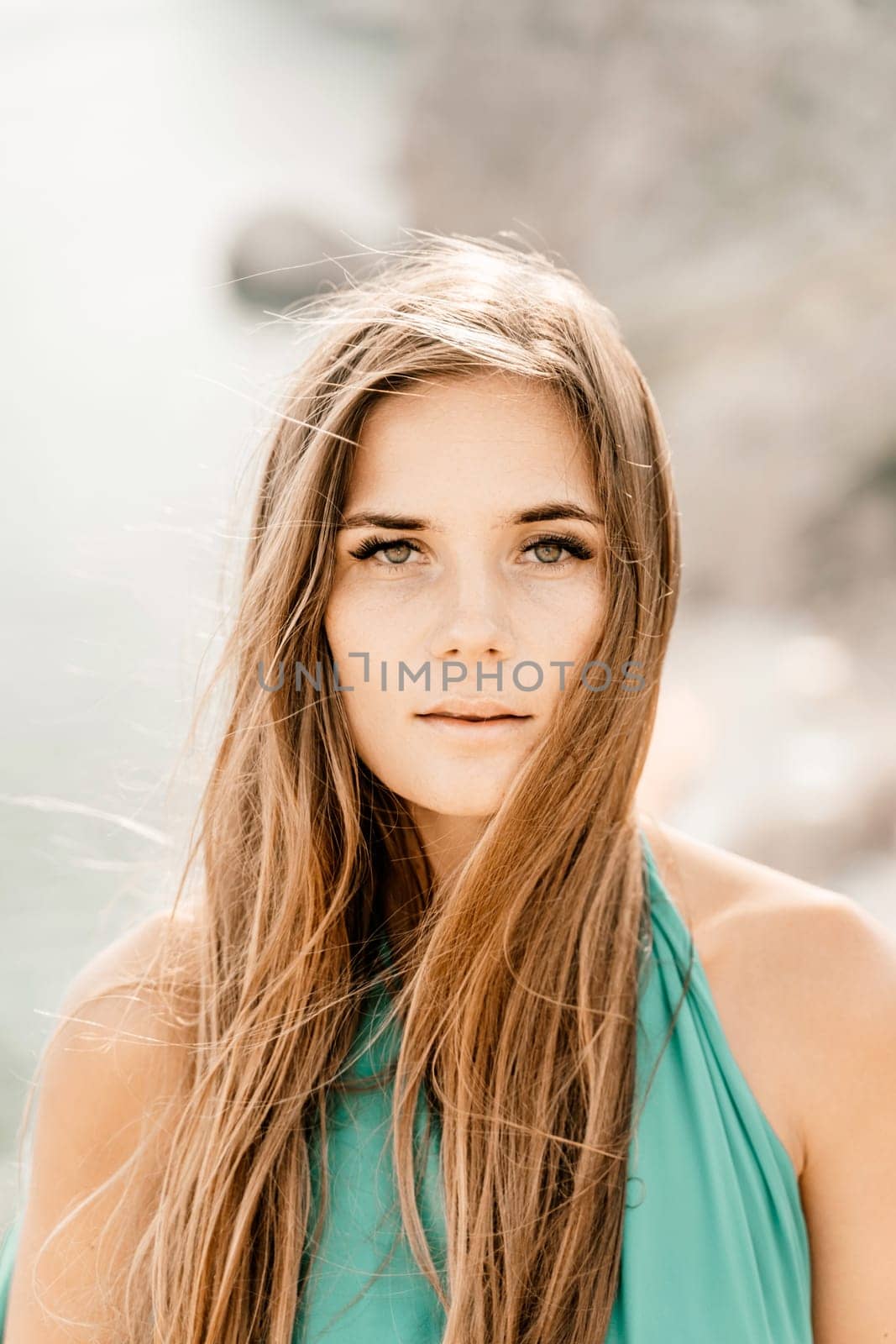 Woman sea green dress. Portrait of a happy woman with long hair in a long mint dress posing on a beach with calm sea bokeh lights on sunny day. Girl on the nature on blue sky background