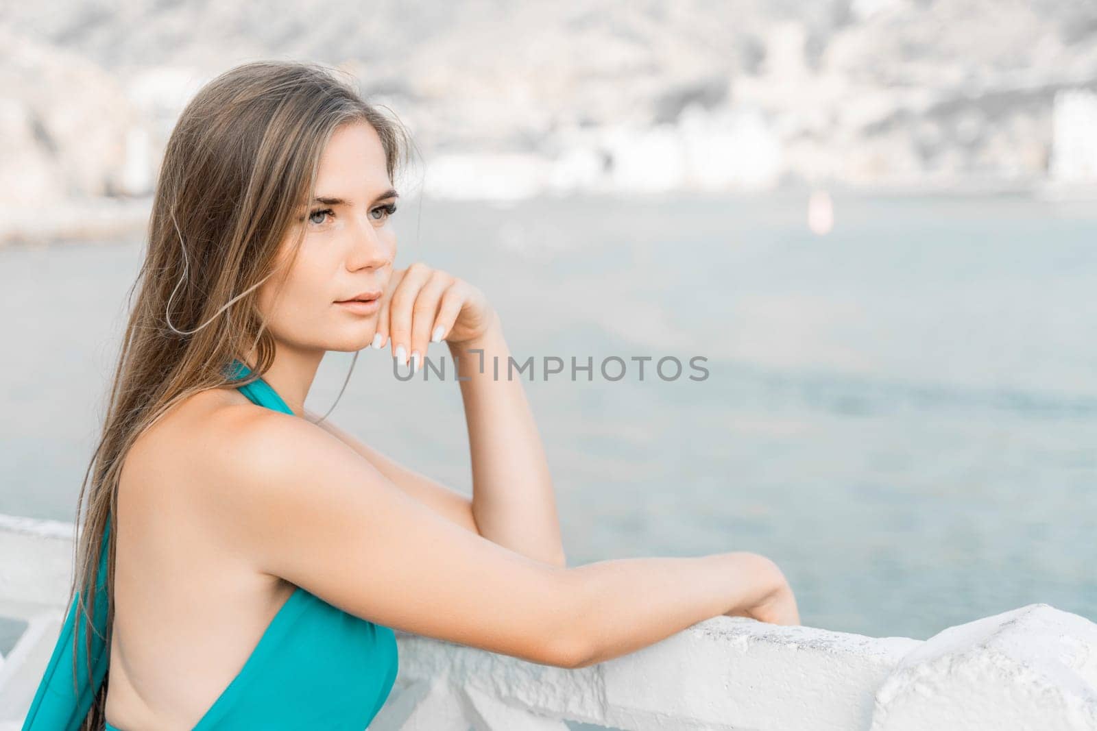 Woman sea trevel green dress. Side view a happy woman with long hair in a long mint dress posing on a beach with calm sea bokeh lights on sunny day. Girl on the nature on blue sky background