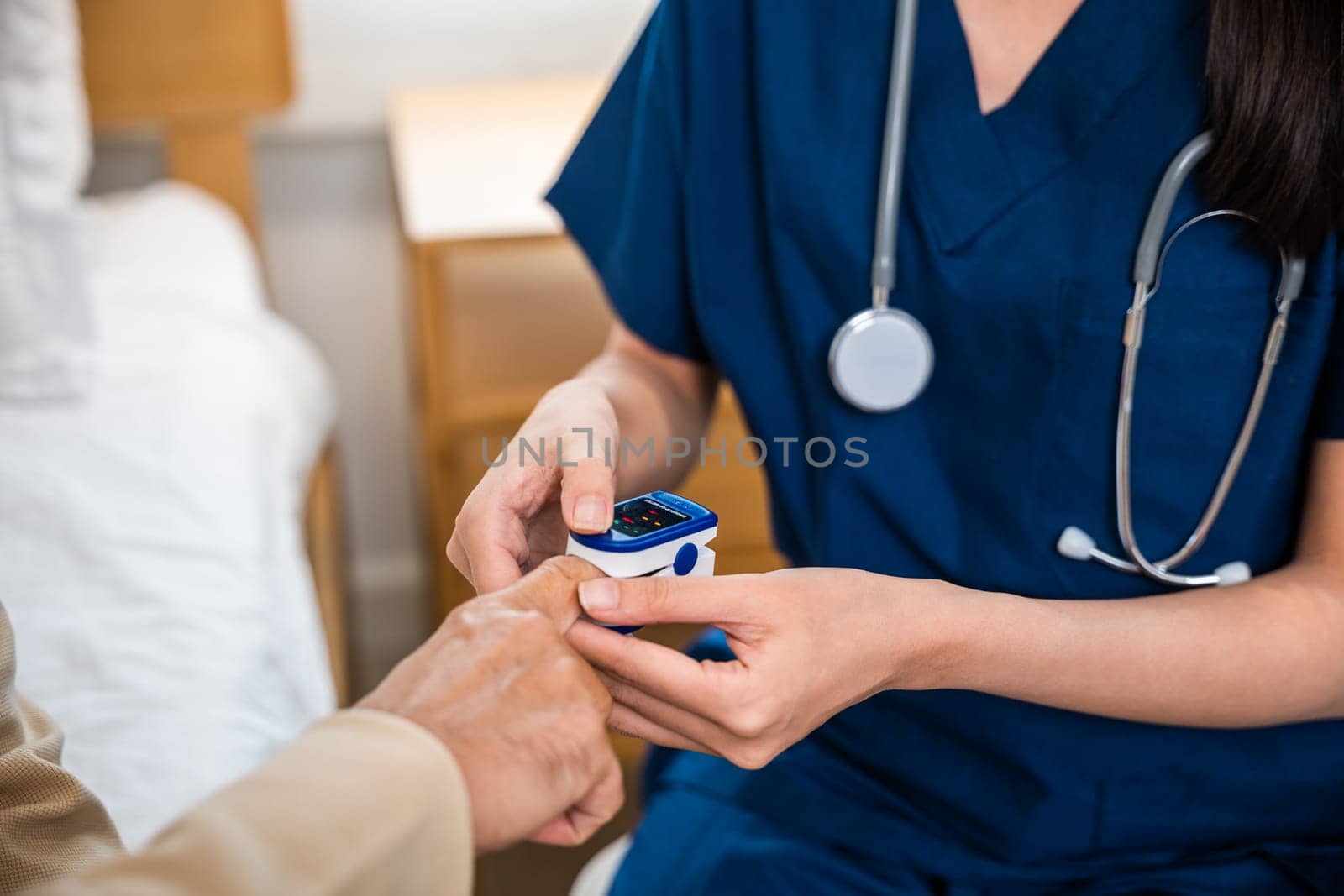 Young woman putting oximeter of finger aged adult patient by Sorapop