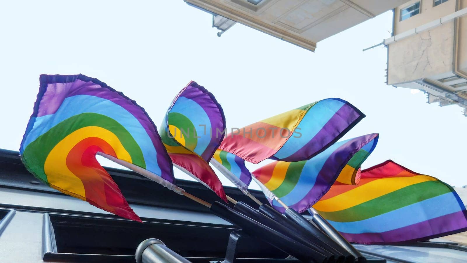 Pride rainbow lgbt gay flag being waved on sky background by Whatawin