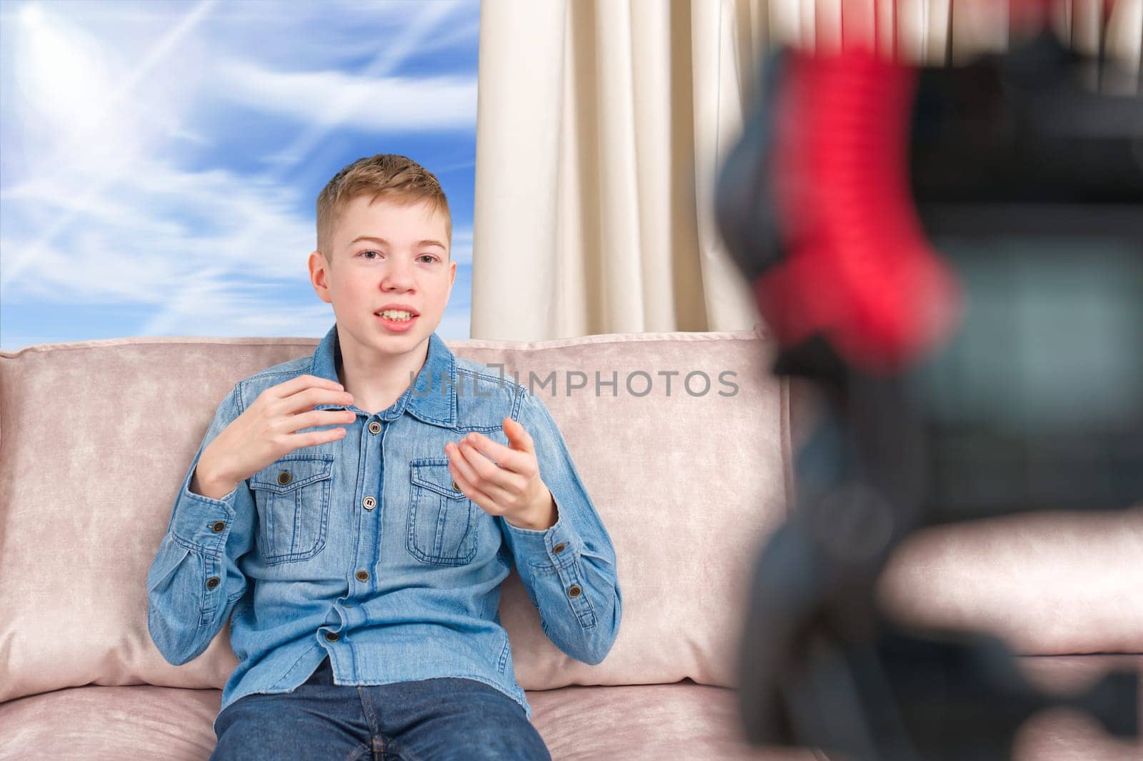beautiful happy boy teenager making video blog for social networks in living room influencer vlogger. making vlog for social media concept, video blogger or influencer making video