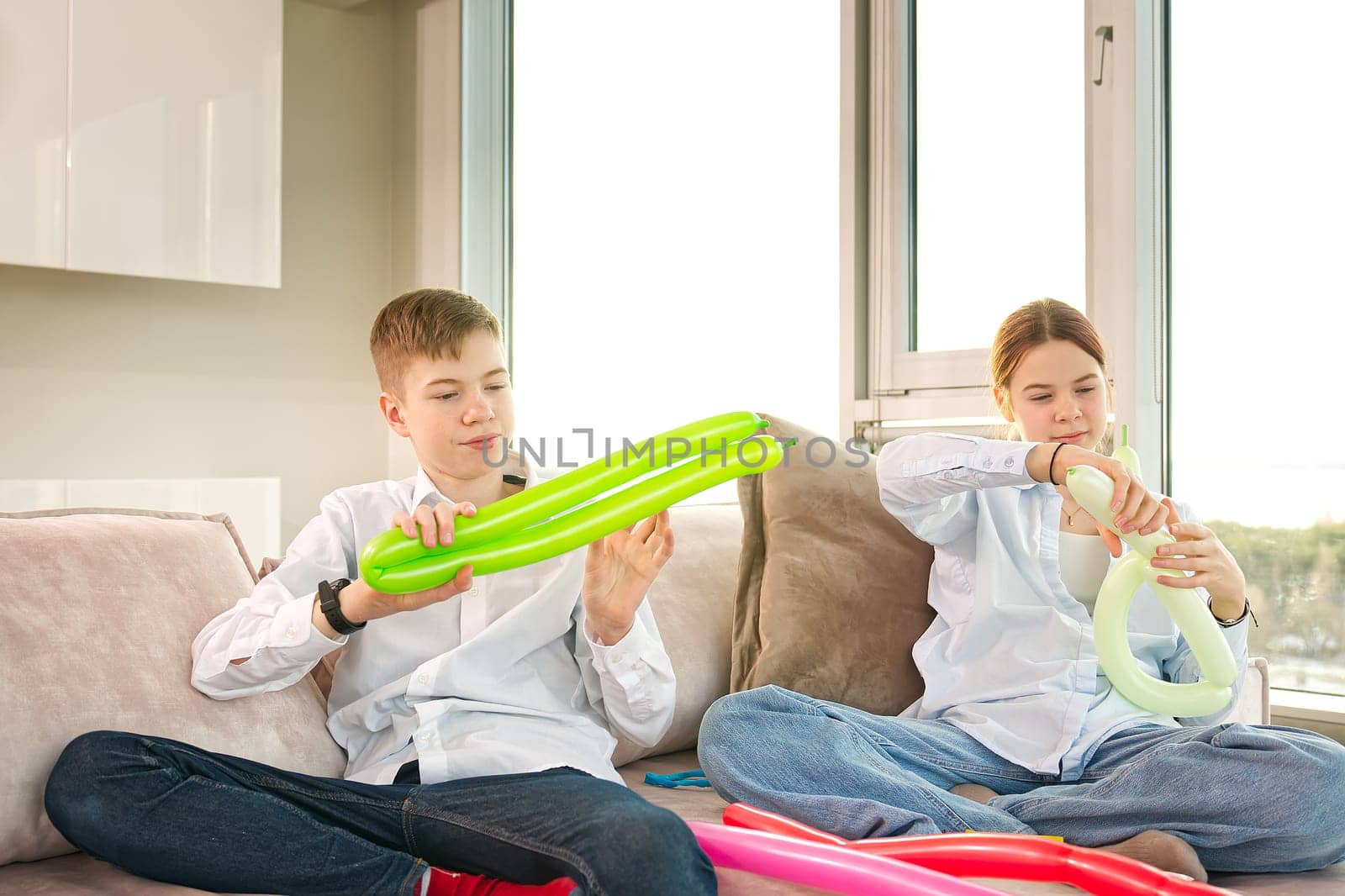 Children inflate modelling balloons. kids having fun with balloons at home