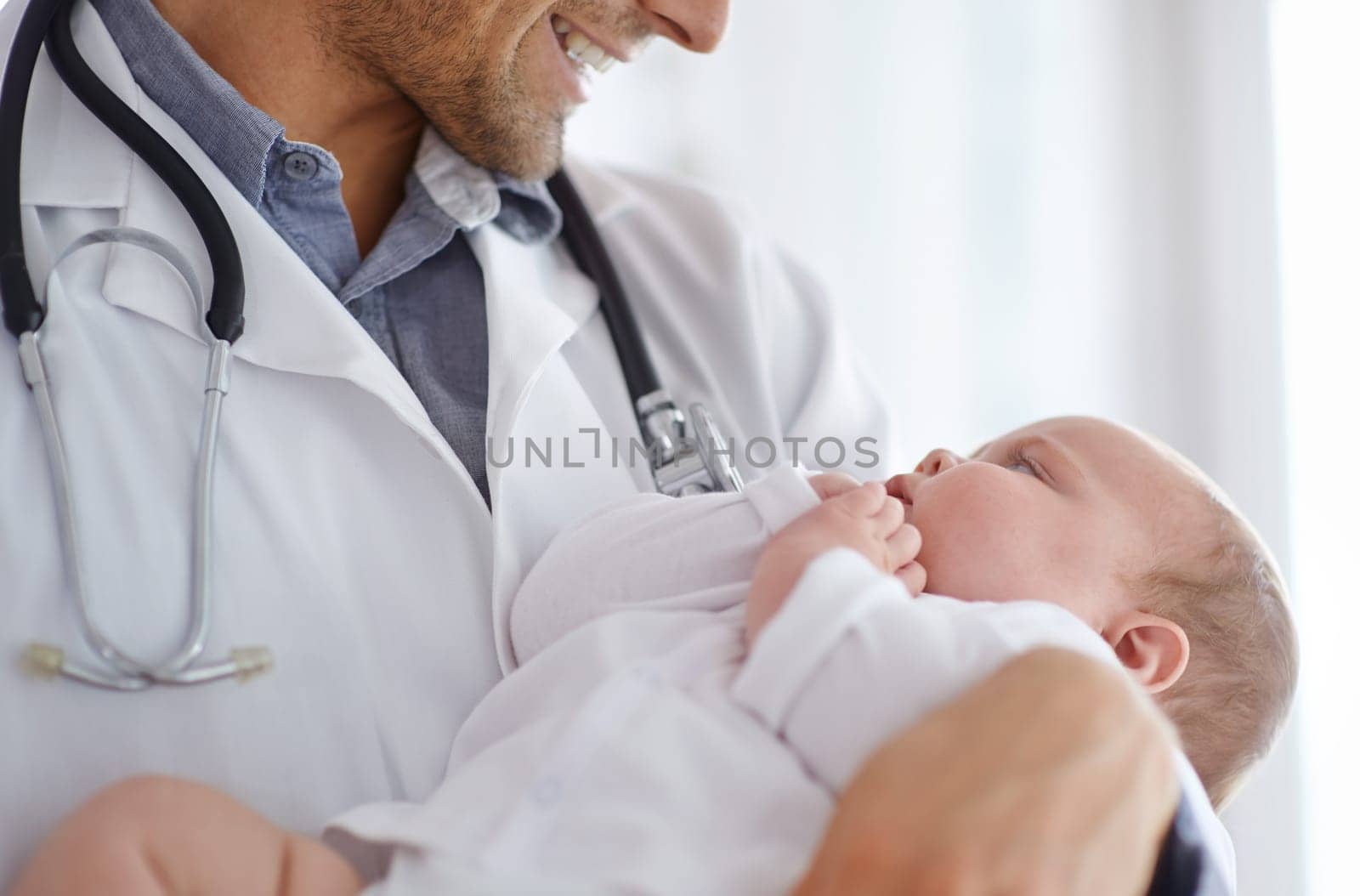 Doctor, pediatrician and holding baby in arms for hospital assessment, medical support and growth. Pediatrics, happy physician and carrying newborn kid in clinic, healthcare service and help children by YuriArcurs