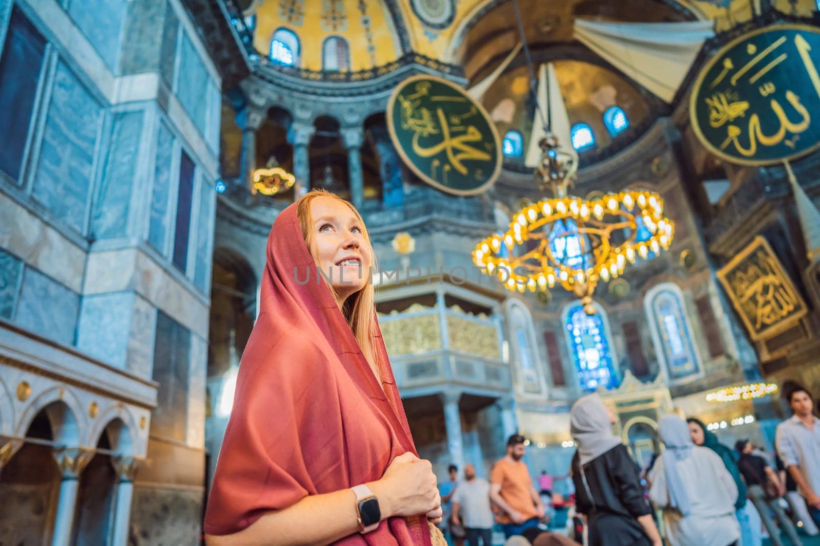 INSCRIPTION - denoting the names of Allah, the Prophet Muhammad, as well as the first 4 caliphs Woman tourist enjoying Hagia Sofia, Ayasofya interior in Istanbul, Turkey, Byzantine architecture, city landmark and architectural world wonder. Turkiye.