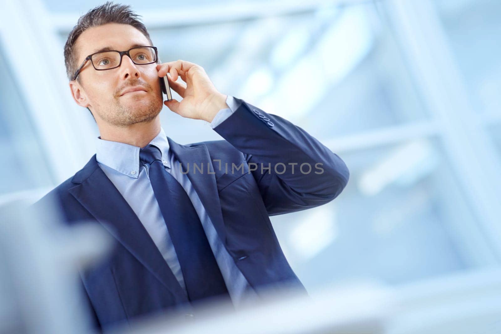 Airport, communication or corporate man with phone call in lobby for loan, investment or negotiation deal. Travel, standing or manager smartphone for networking, b2b network or mockup communication by YuriArcurs