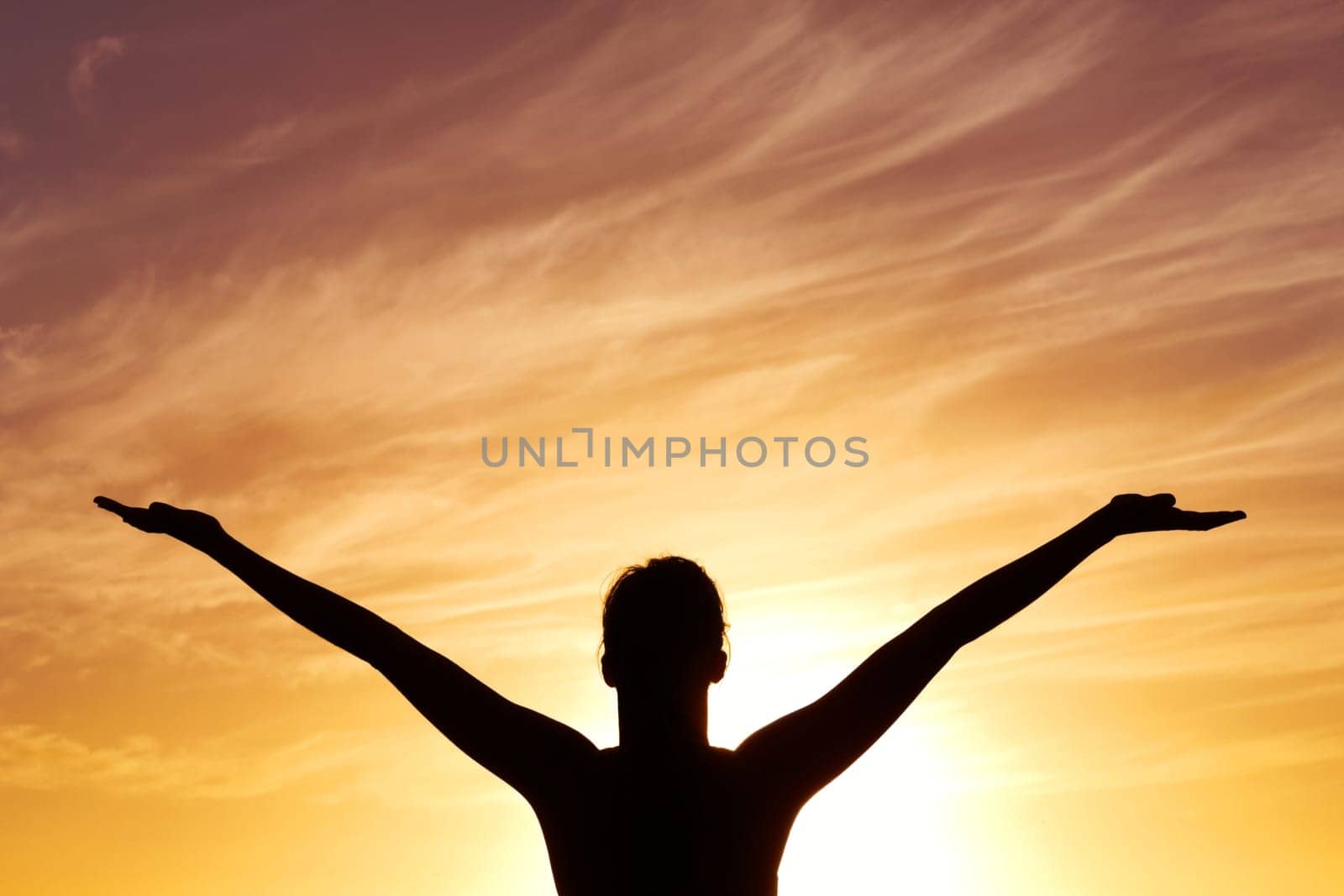 Silhouette, sunset with person, open arms and freedom outdoor, orange sky with fresh air and celebrate life. Meditation, wellness and healing with peace, shadow and horizon with worship or spiritual.