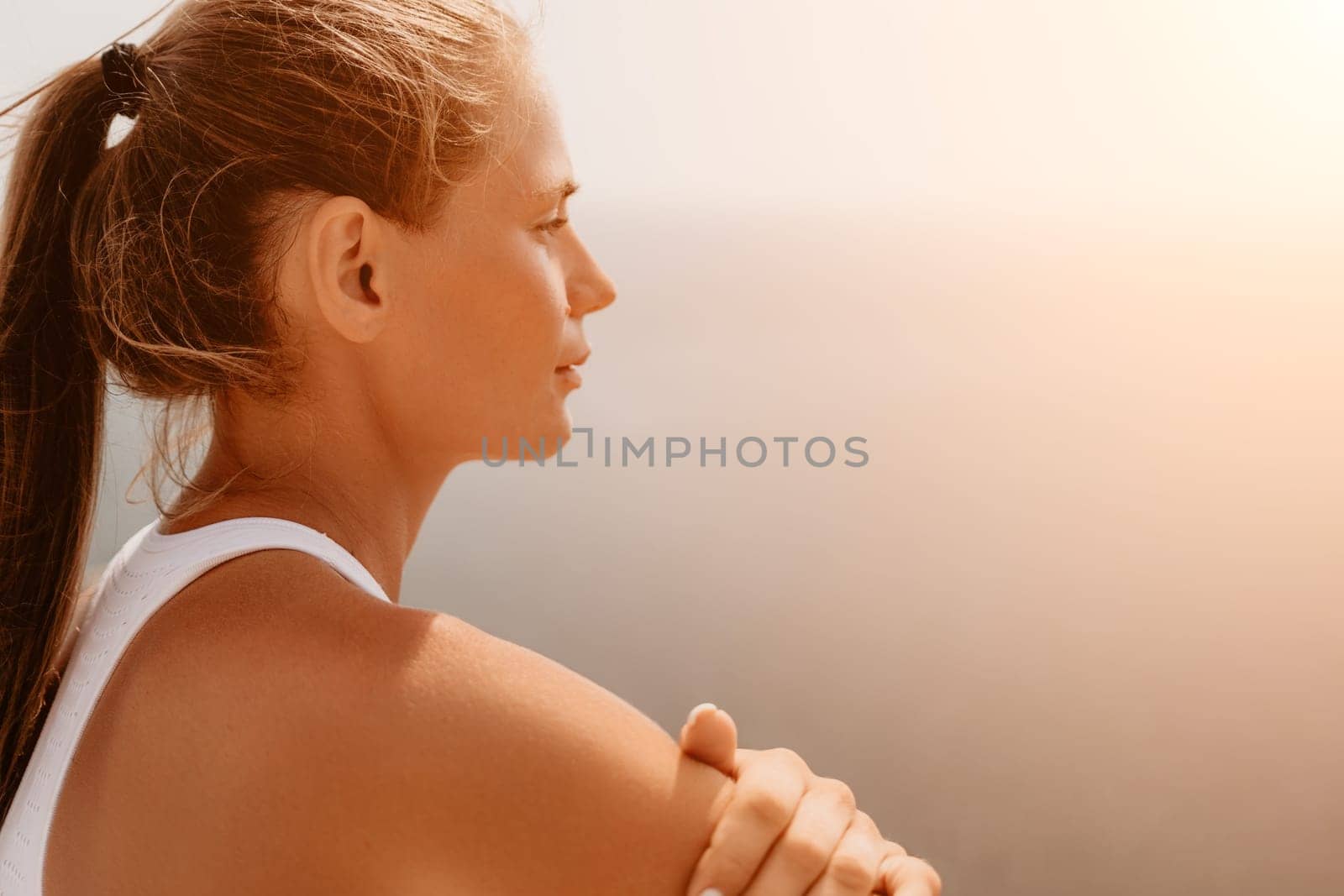 Woman sea pilates. Sporty middle-aged woman training in pilates on yoga mat by sea. concepts of health, wellness, and mindfulness in exercise, promoting the benefits of active and balanced lifestyle by panophotograph