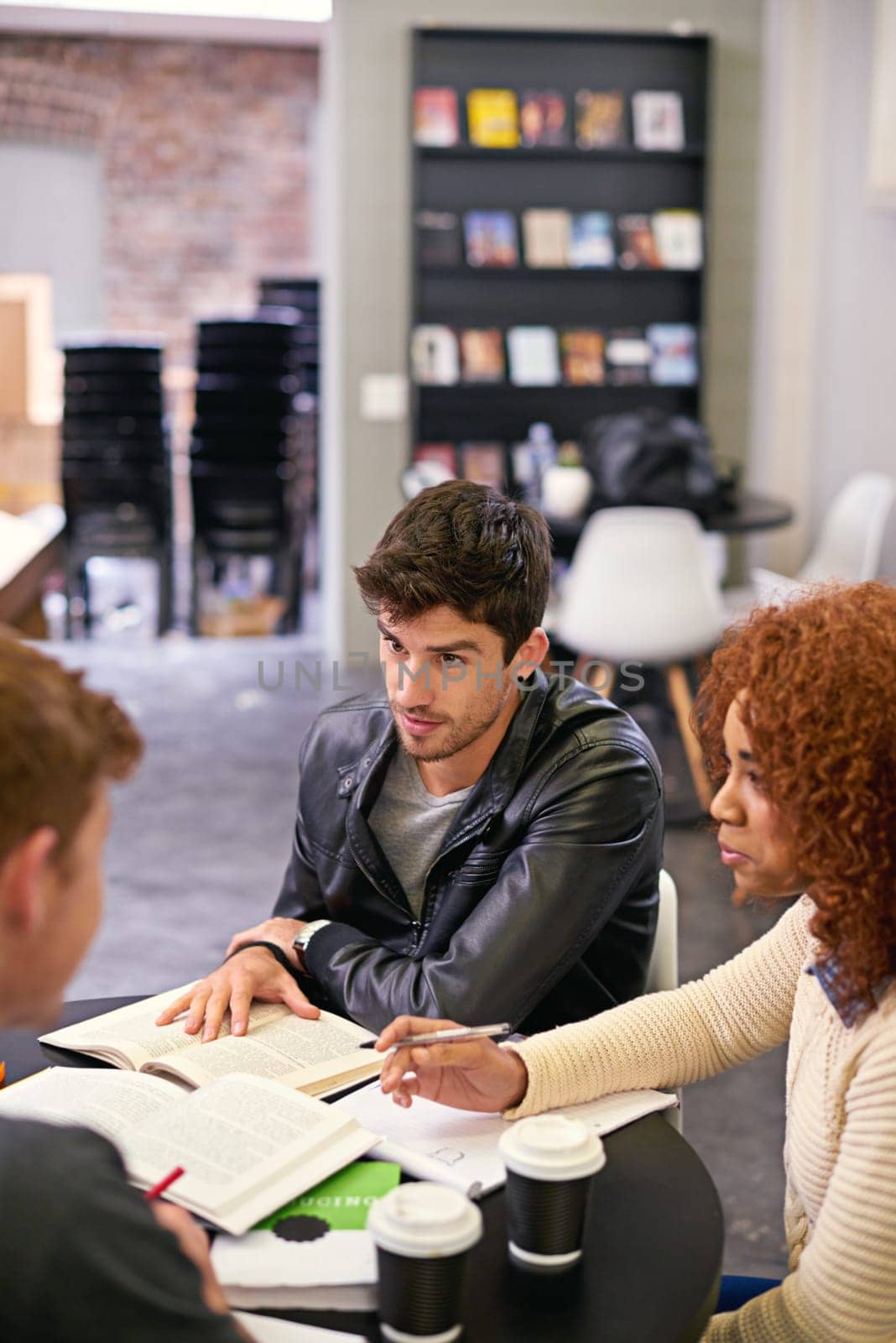 Students studying in a group in library on campus, people learning for university education and scholarship. Academic development, knowledge with men and woman, study with books for research by YuriArcurs