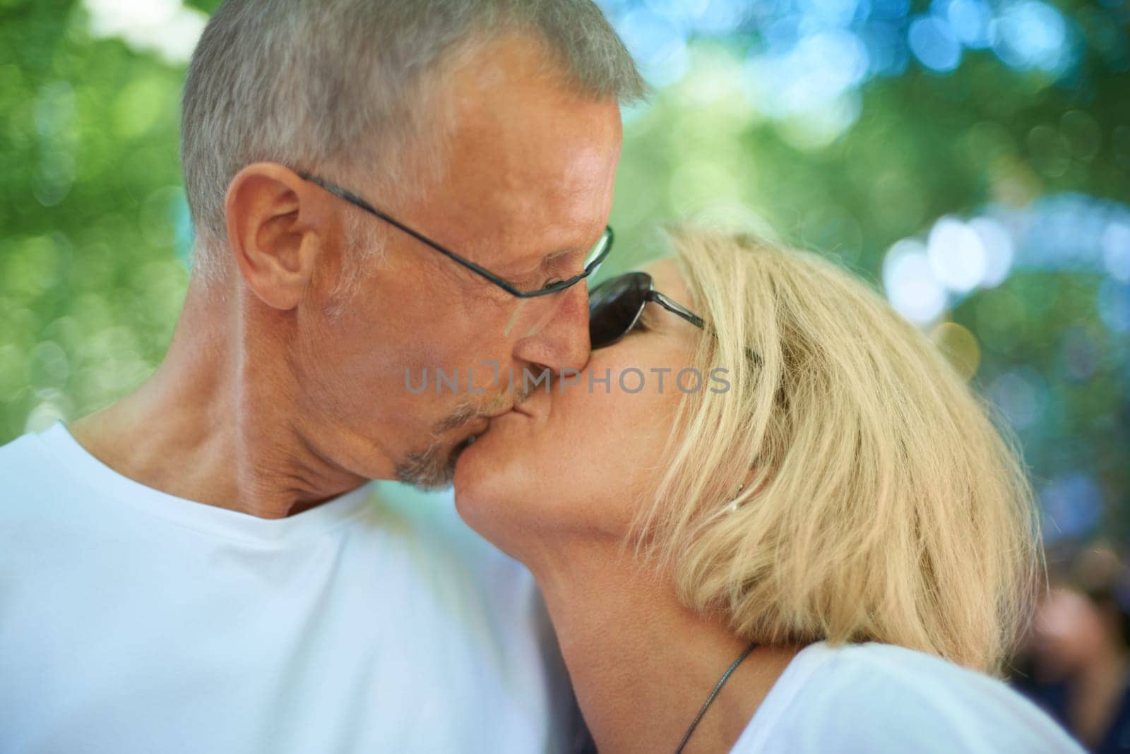 Keeping the romance alive. an affectionate mature couple at an outdoor festival. by YuriArcurs