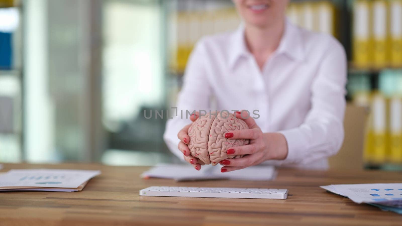 Female hands putting human brain on keyboard closeup. Artificial intelligence concept