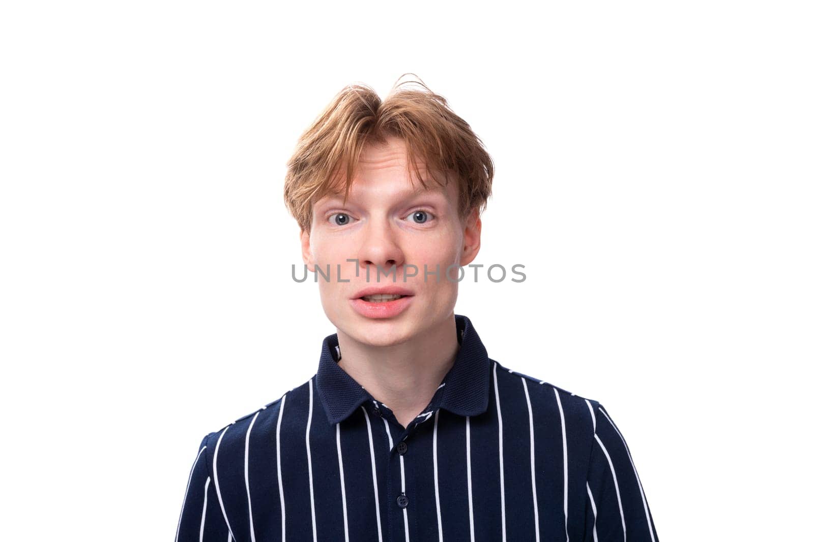 close-up portrait of a stylish handsome young blond man keeping a secret on a white background.