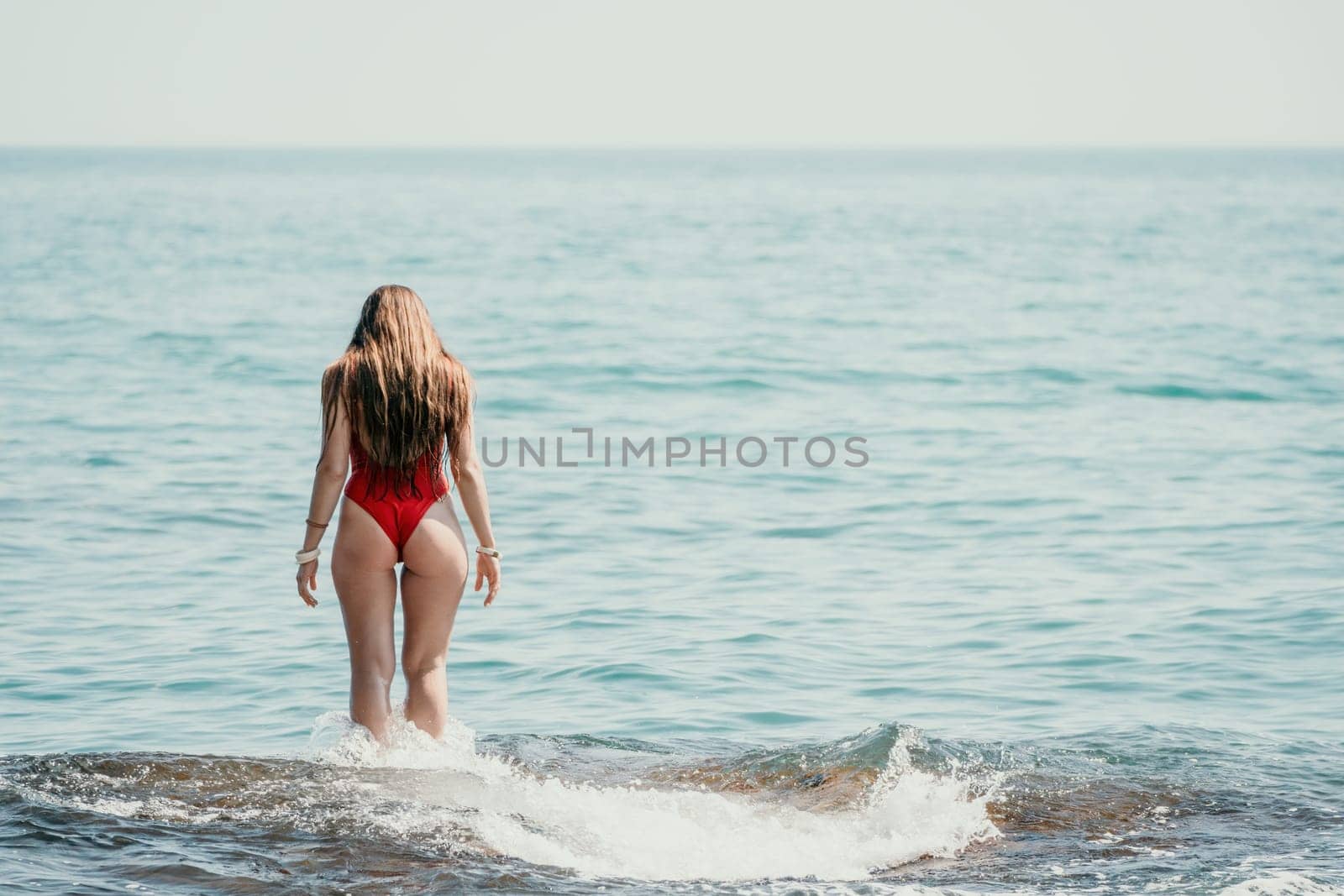 Woman sea yoga. Back view of free calm happy satisfied woman with long hair standing on top rock with yoga position against of sky by the sea. Healthy lifestyle outdoors in nature, fitness concept.