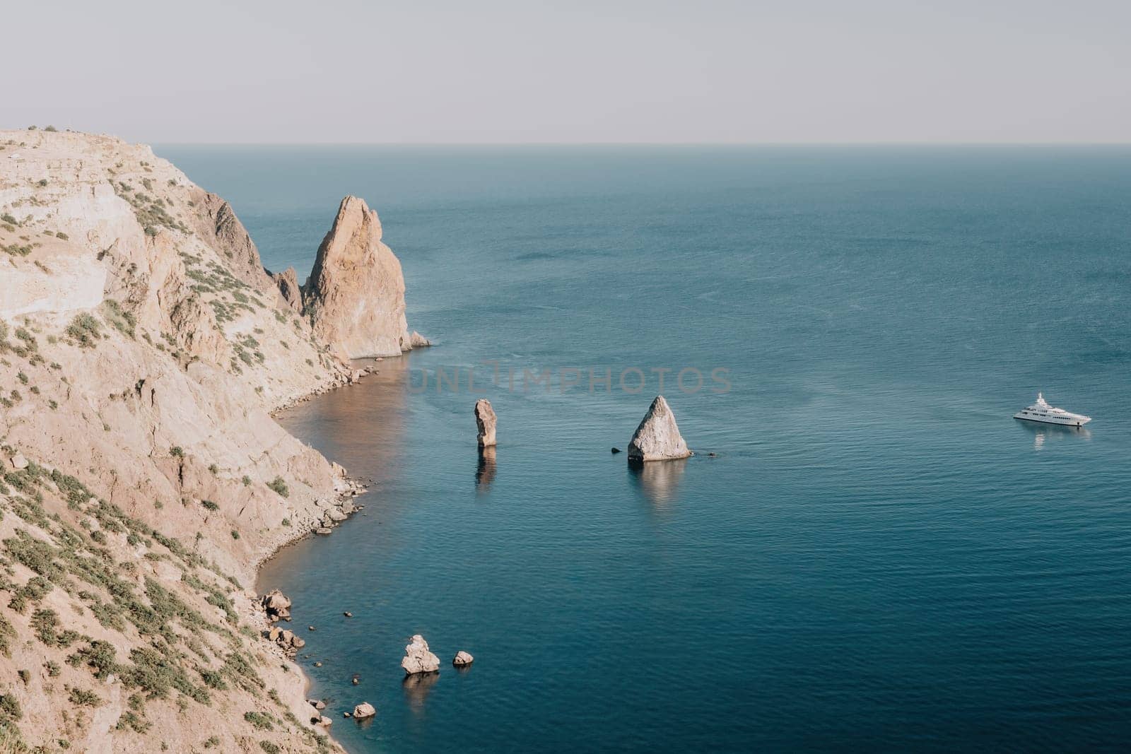 Aerial view from above on calm azure sea and volcanic rocky shores. Small waves on water surface in motion blur. Nature summer ocean sea beach background. Nobody. Holiday, vacation and travel concept by panophotograph