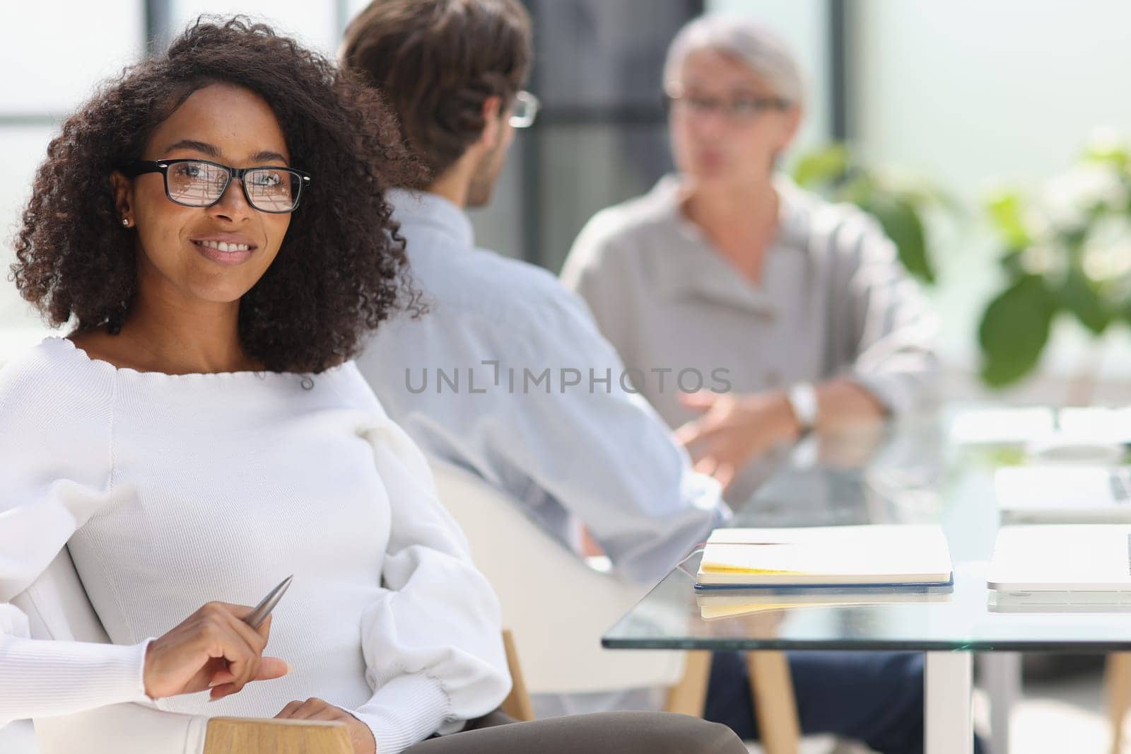 young attractive african american woman in the office sitting at the table