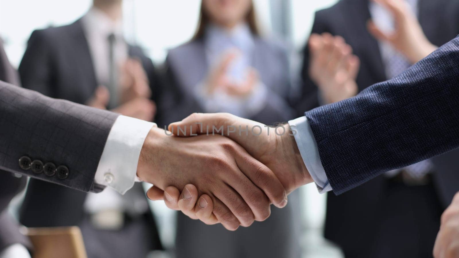 businessmen shaking hands starting teamwork partnership standing in corporate work space hallway
