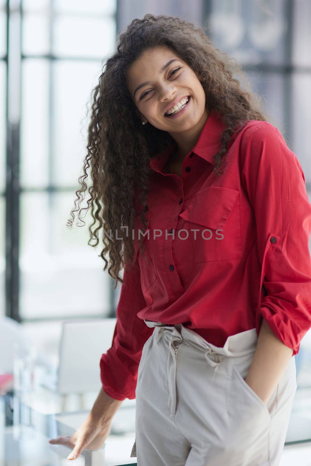 Image of young beautiful joyful woman smiling while working with laptop in office