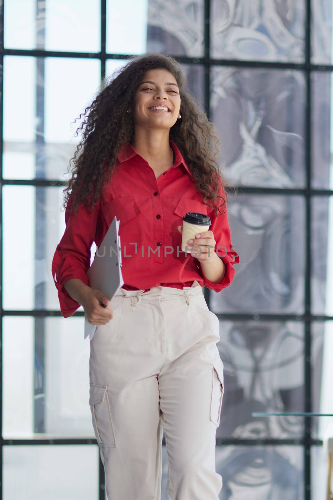 Im ready to start the day. an attractive young businesswoman standing alone in the office with her arms folded