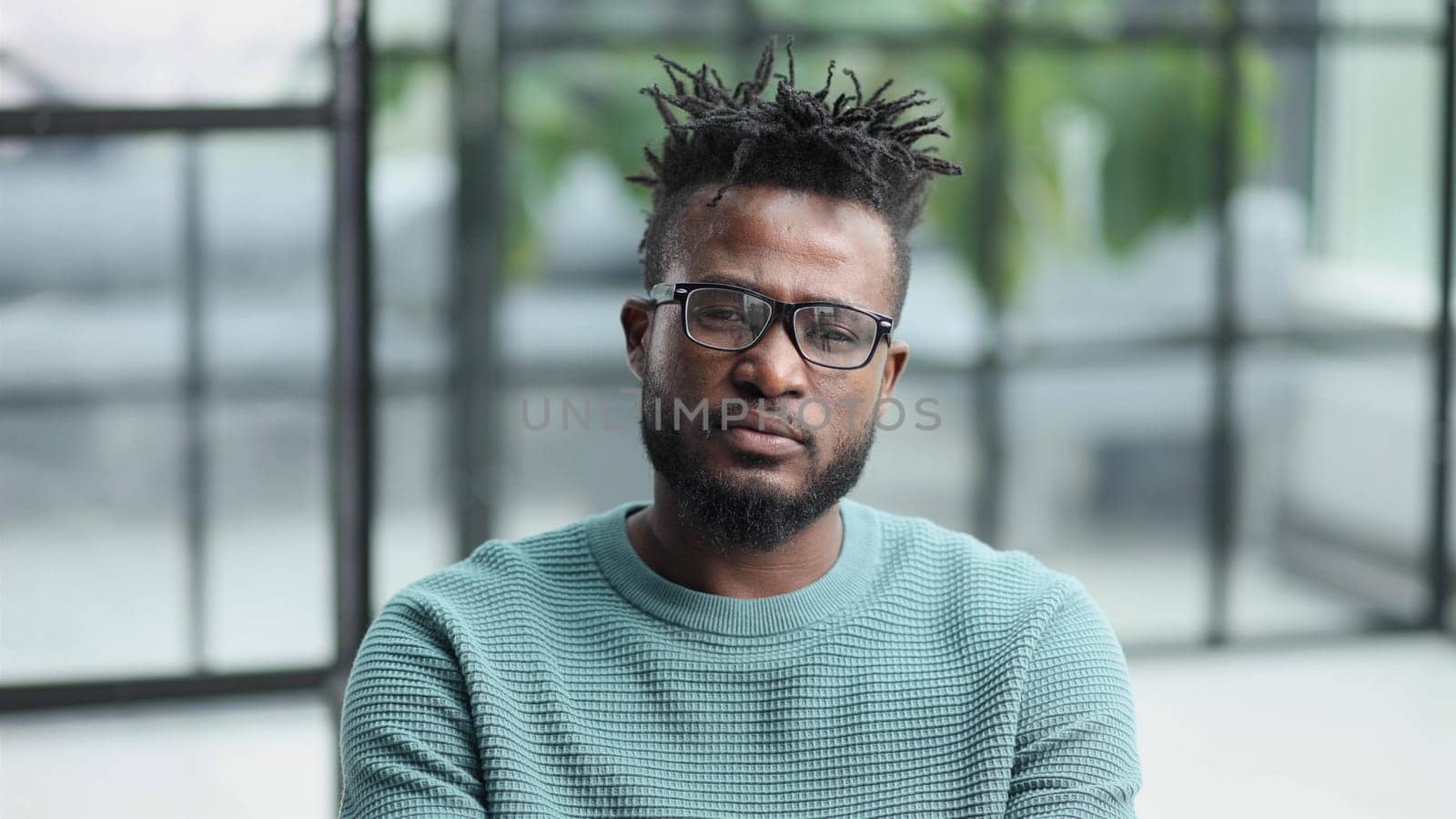Portrait of a serious african american man, shaking his finger, warning and preventing you from something bad, looking at the camera with a worried expression.
