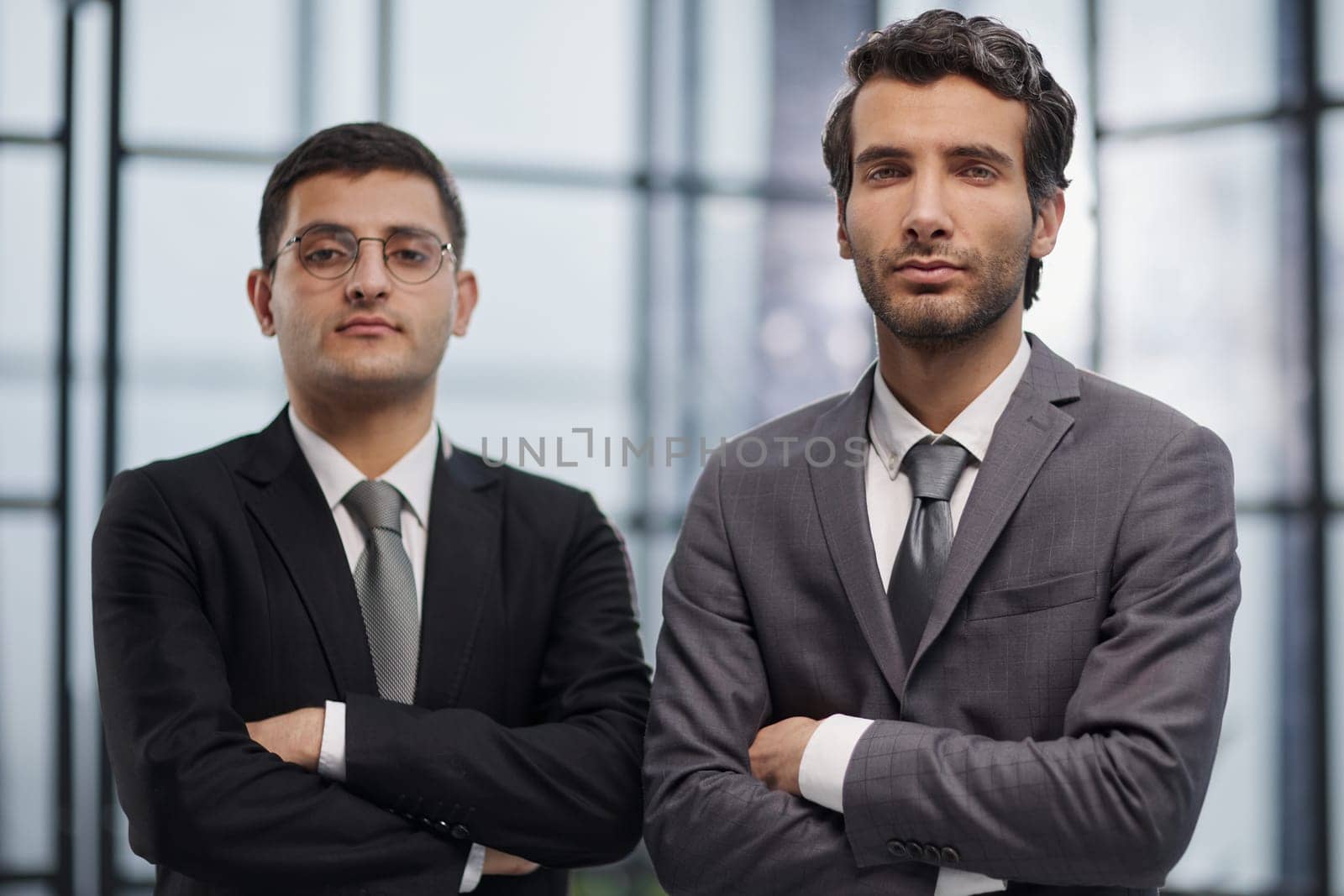 Two men business workers standing with arms crossed gesture at office