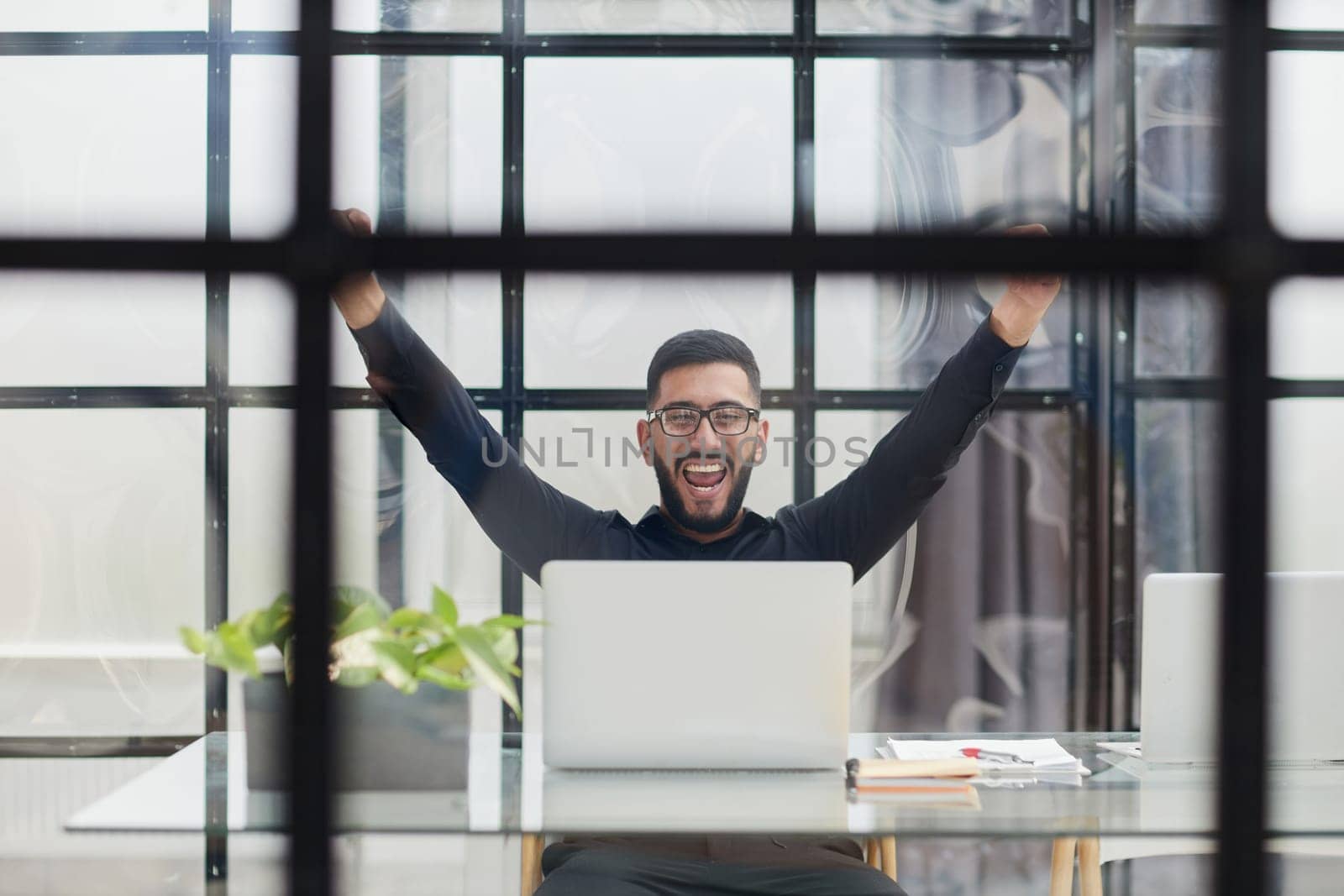 Business man sitting at his desk in the office with a laptop