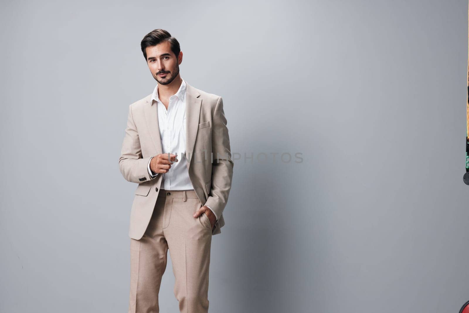 studio man occupation standing beige folded stylish suit confident crossed isolated successful business handsome smile attractive copyspace happy portrait businessman smiling