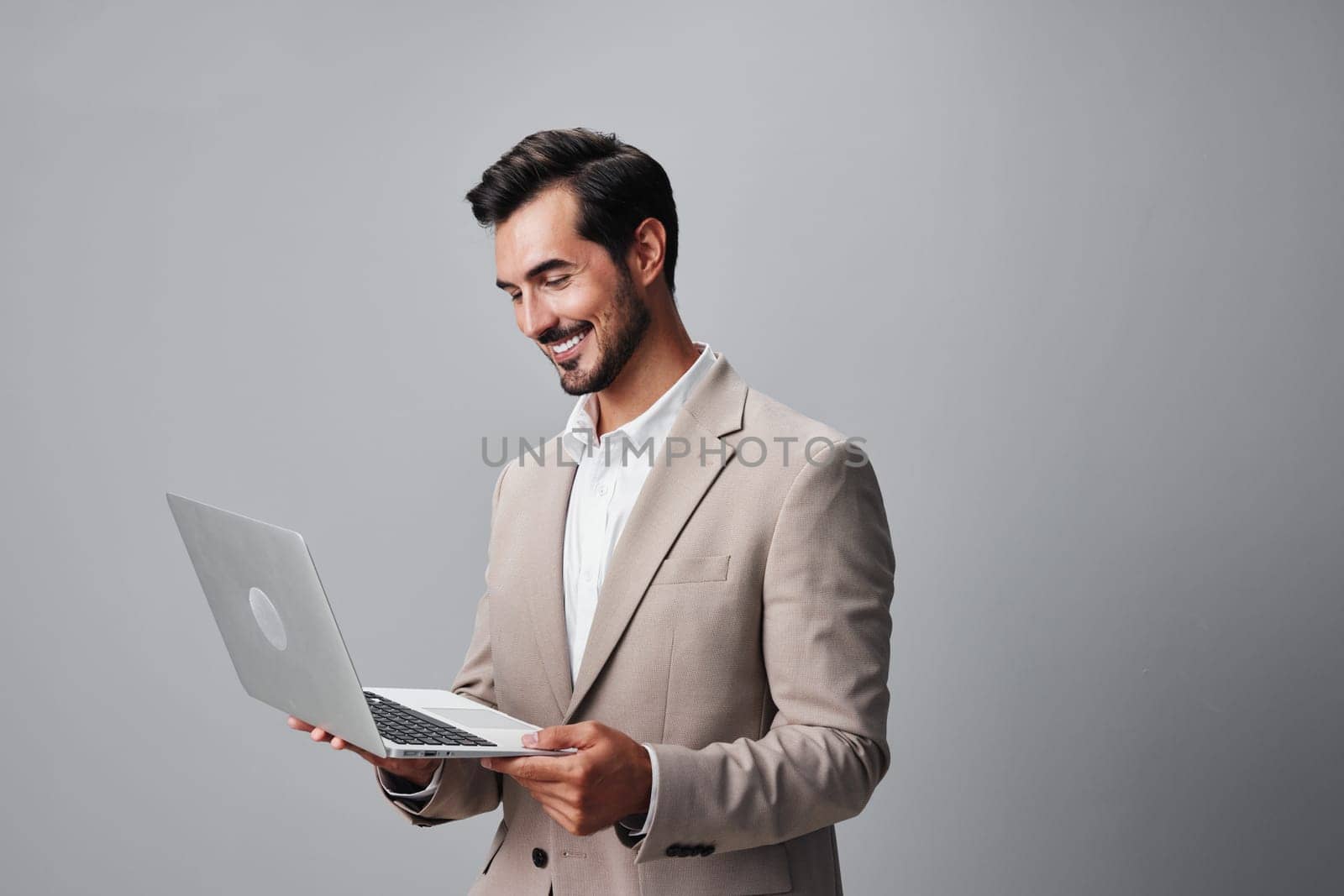 man using laptop professional internet computer smiling model job studio young online portrait wireless business suit freelancer corporate cheerful copyspace handsome