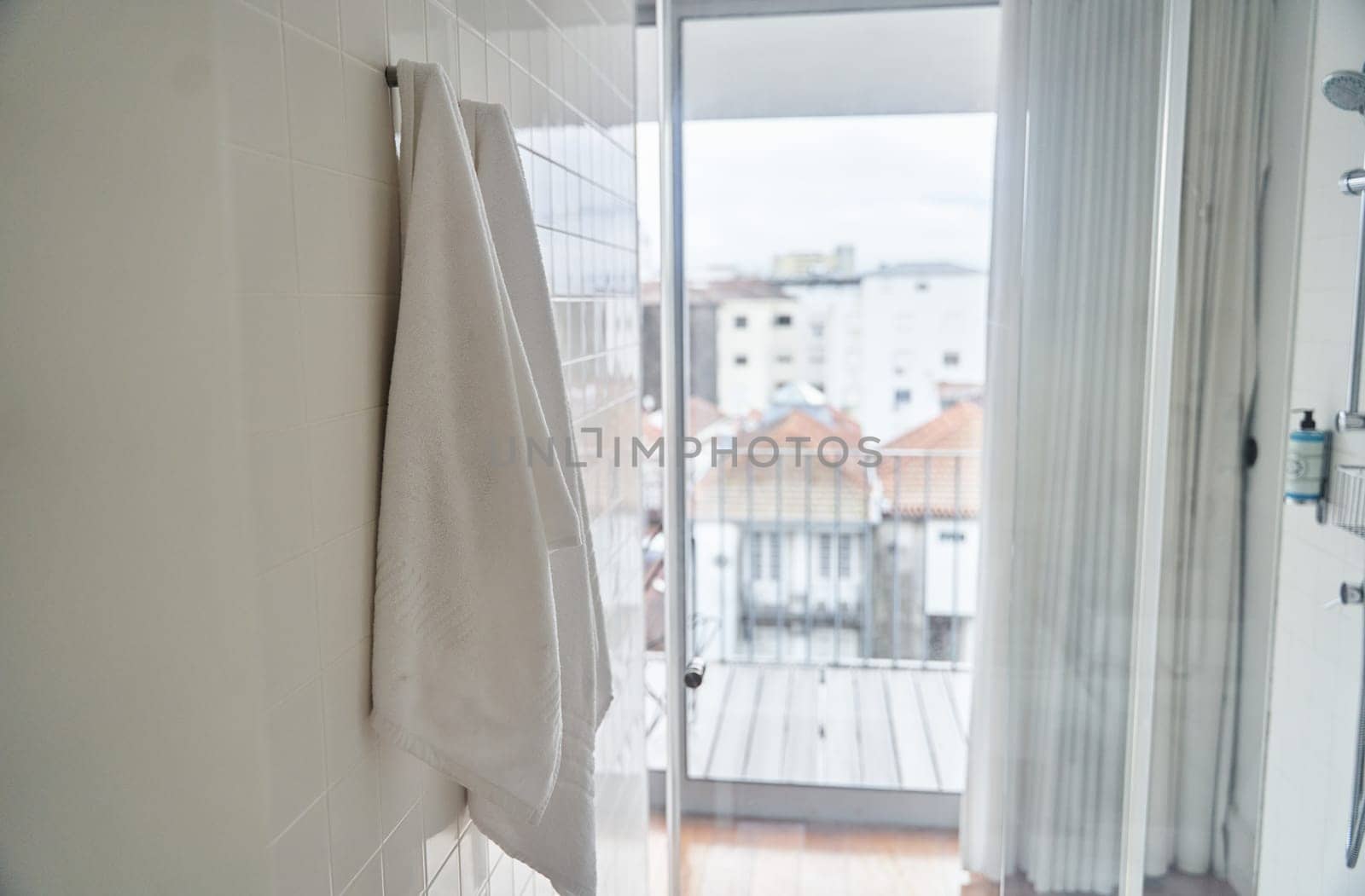 Two white towels hanging in the hotel shower room. High quality photo