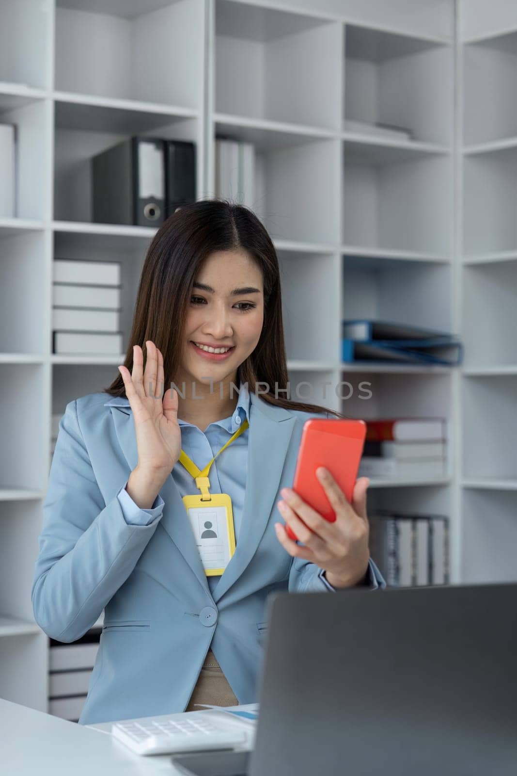 Businesswoman is making video call over phone in office.