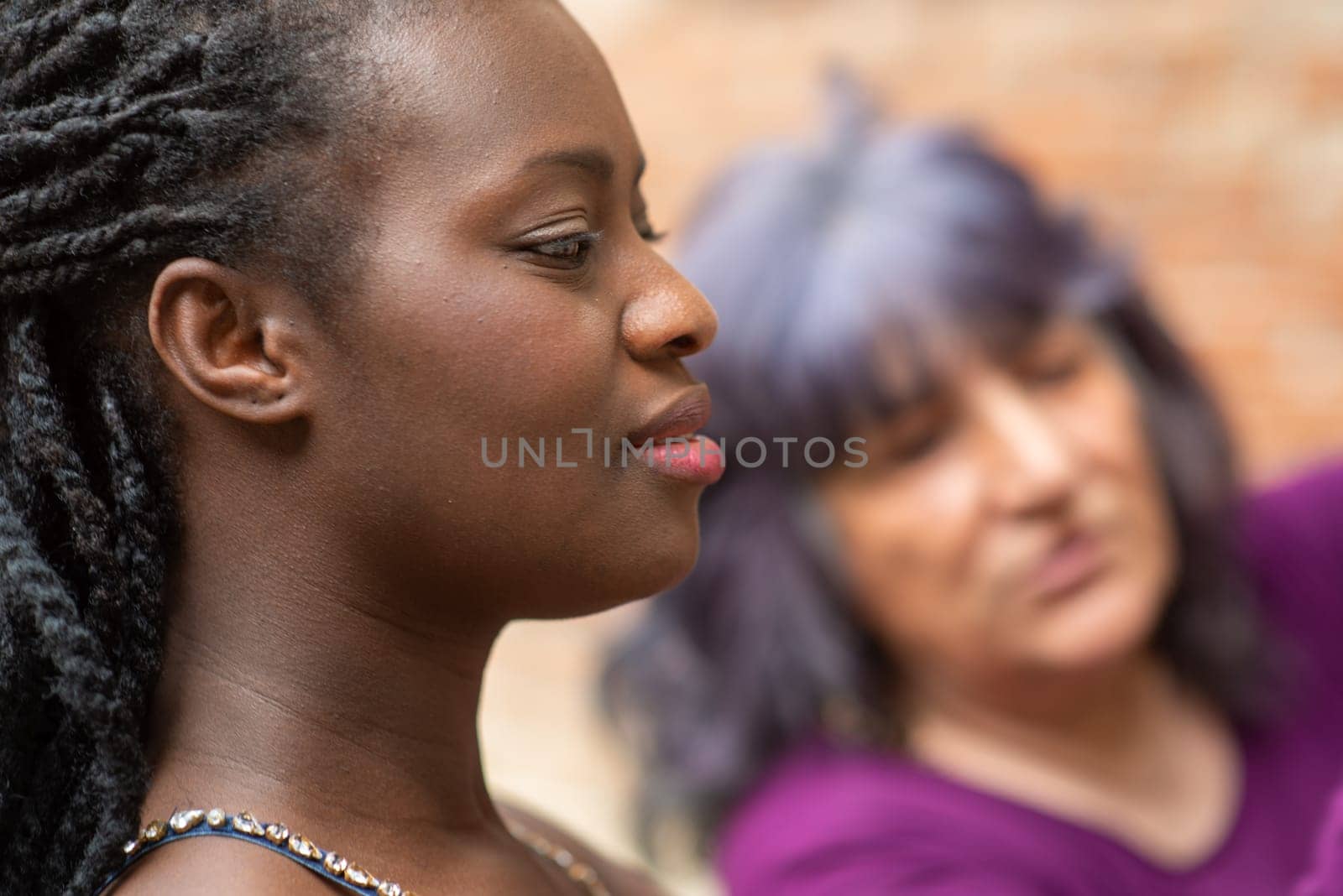 Diverse couple having fun in summertime in old village, outdoors. Funny expression. LGBT standout.