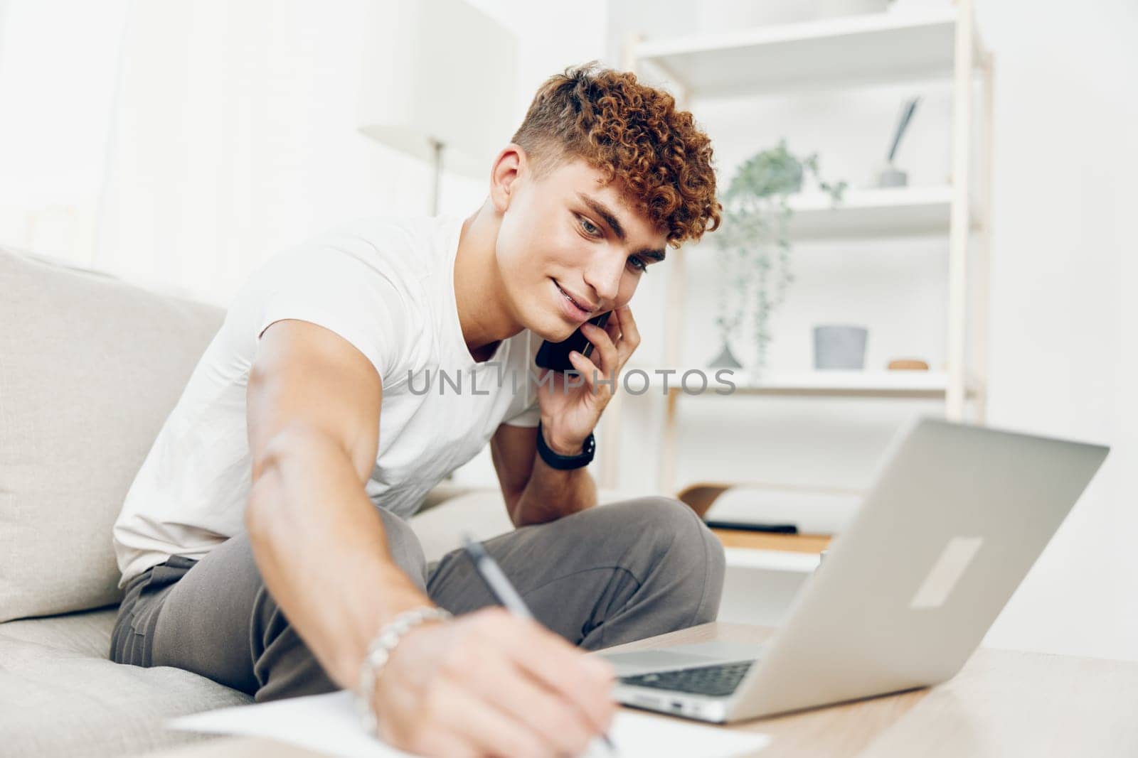 man internet cell male lifestyle sitting online blissful person technology cellphone talking laptop couch text message using student holding freelancer