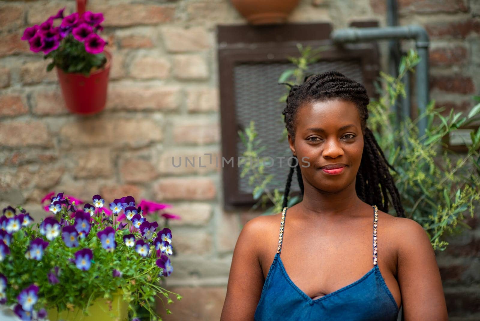 relaxed young black woman sitting. Stylish model. Braid dreadlock hairstyle. Confident African female in selective focus outdoors, fashion style, happiness concept. Outdoors.