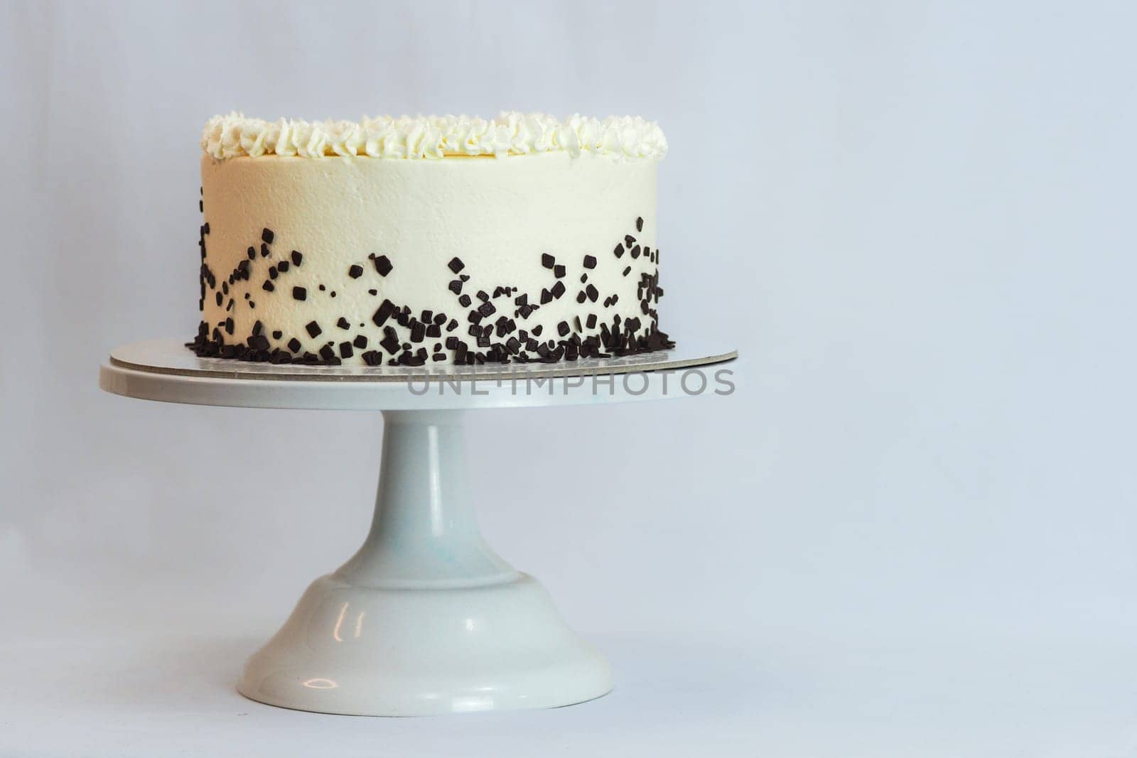 studio isolated shot of frosted white icing cake on white background by verbano