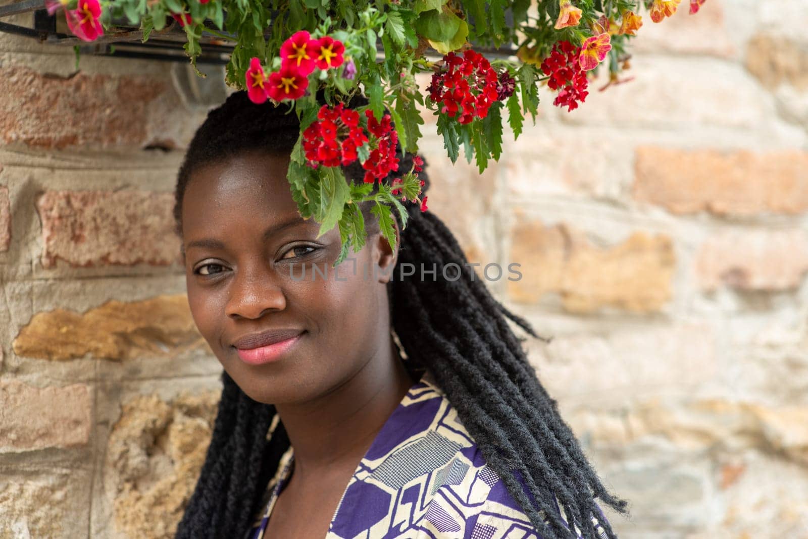 relaxed young black woman sitting. Stylish model. Braid dreadlock hairstyle. Confident African female in selective focus outdoors, fashion style, happiness concept. Outdoors.