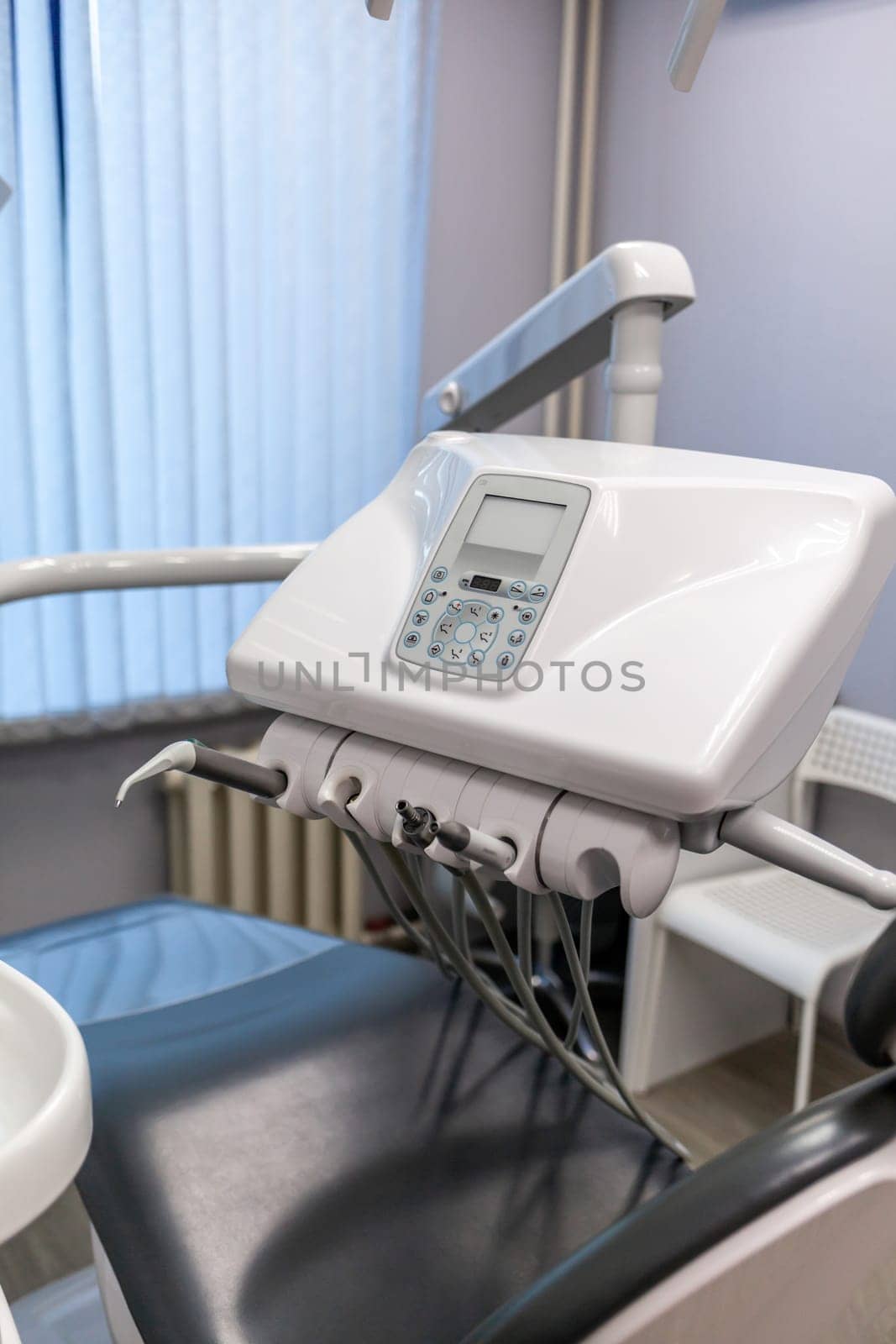 Dental interior office with modern equipment. Modern dental practice. Dental chair and other accessories used by dentists in blue, medic light
