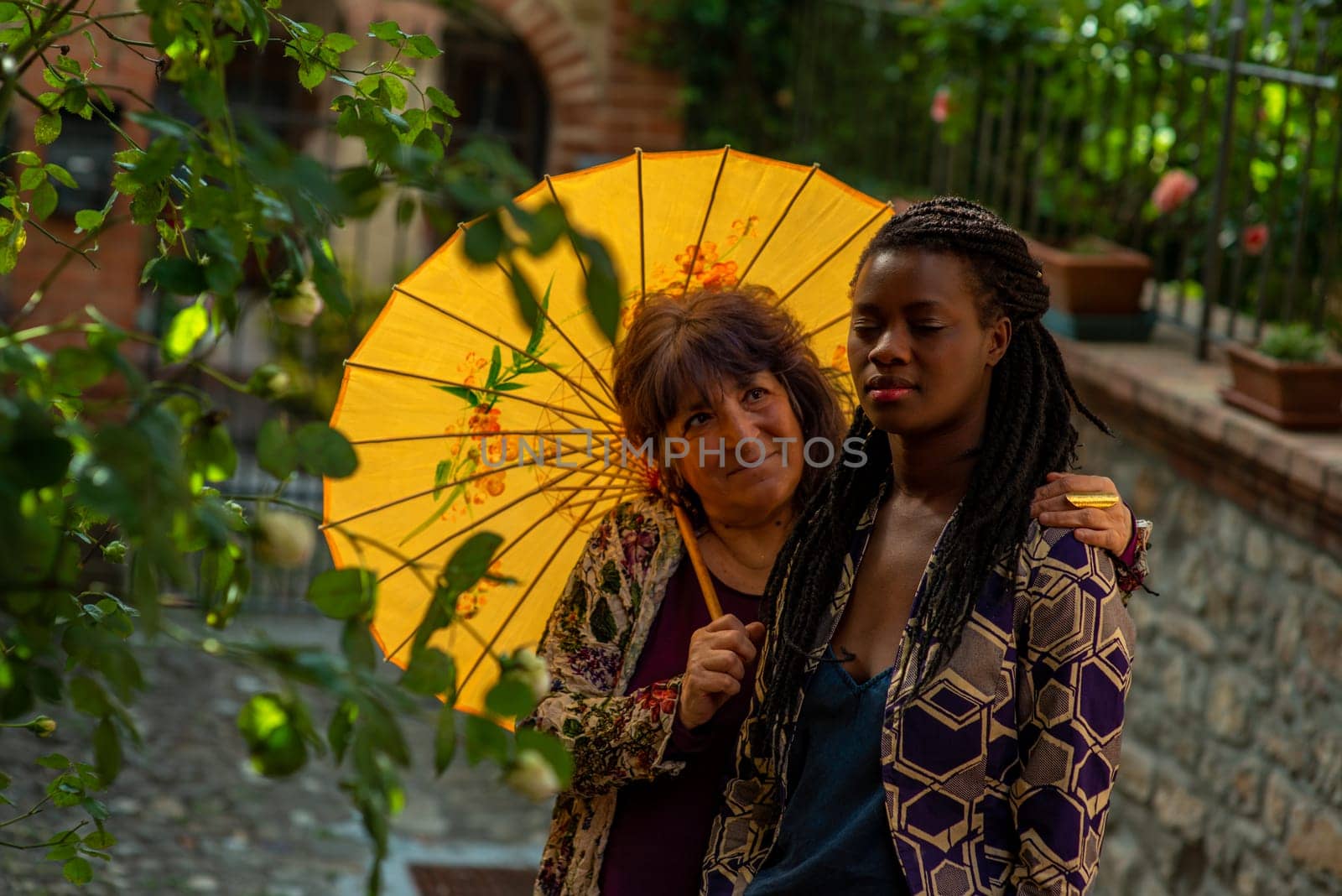 Diverse couple having fun in summertime in old village, outdoors. Funny expression. LGBT standout.