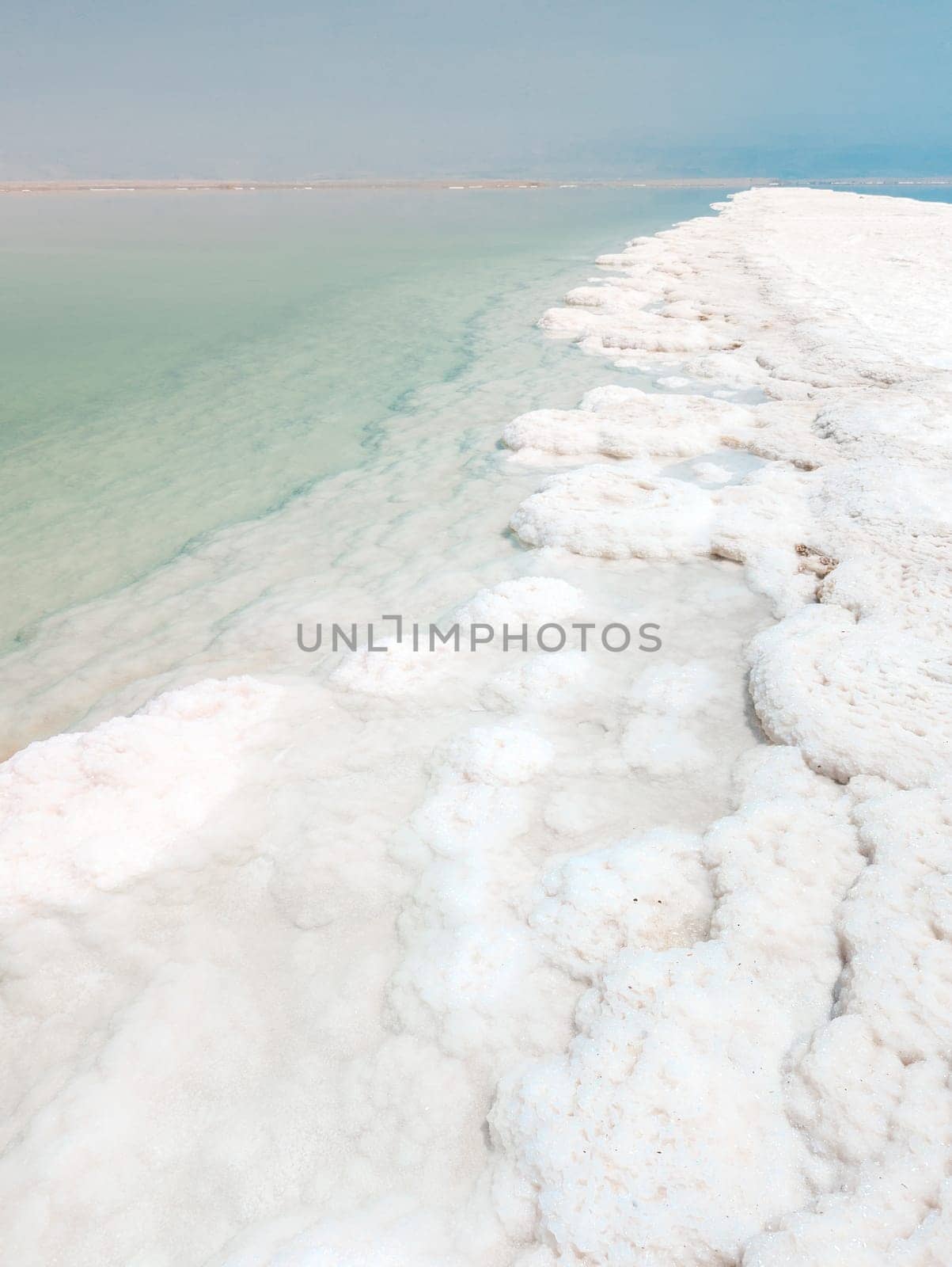 Landscape view on Dead Sea salt crystals formations, clear cyan green water at Ein Bokek beach, Israel by Len44ik
