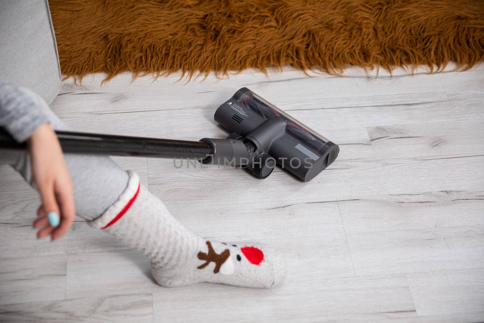 The girl sat on the sofa to relax after vacuuming the entire apartment. Cleanliness and order requires regularity throughout the apartment.