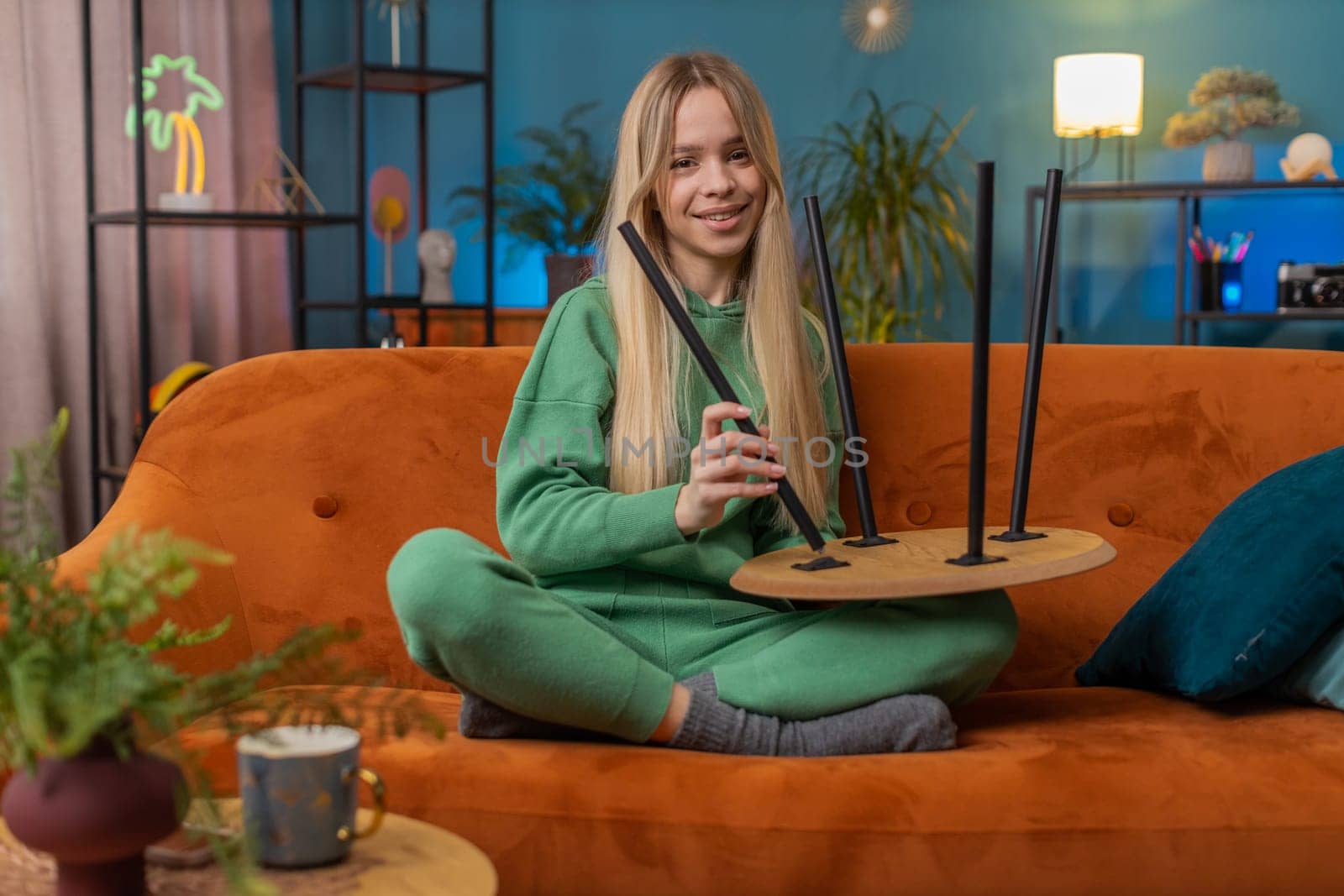 Happy woman finishing assembling furniture at home. Successful table desk collect, repair, fixing. Teen girl after moving into new apartment. Advertisement of a furniture store. Mortgage, lifestyle