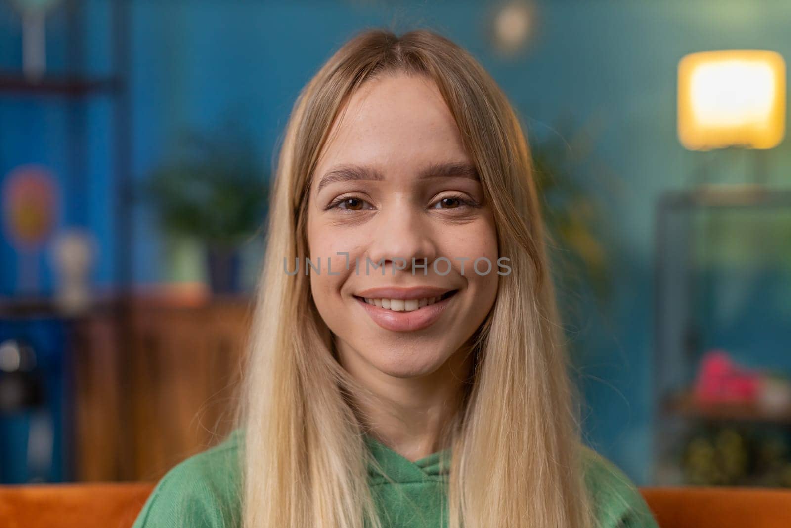 Portrait of happy calm woman at home couch smiling friendly, glad expression looking away dreaming resting, relaxation feel satisfied concept good news, celebrate win. Young teen girl in living room