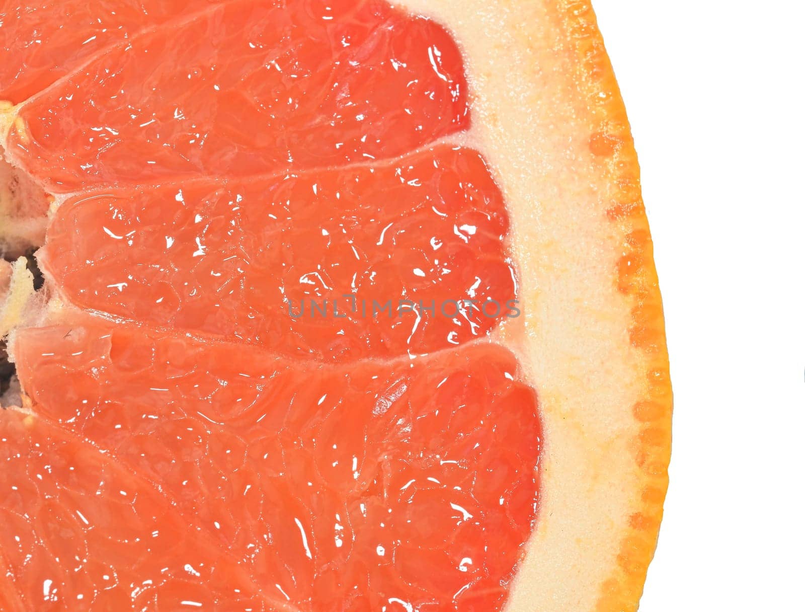 Close-up of a grapefruit slice on white background. Slice of ripe grapefruit. Close-up of fresh grapefruit slice on wite background. Macro horizontal image. by roman_nerud