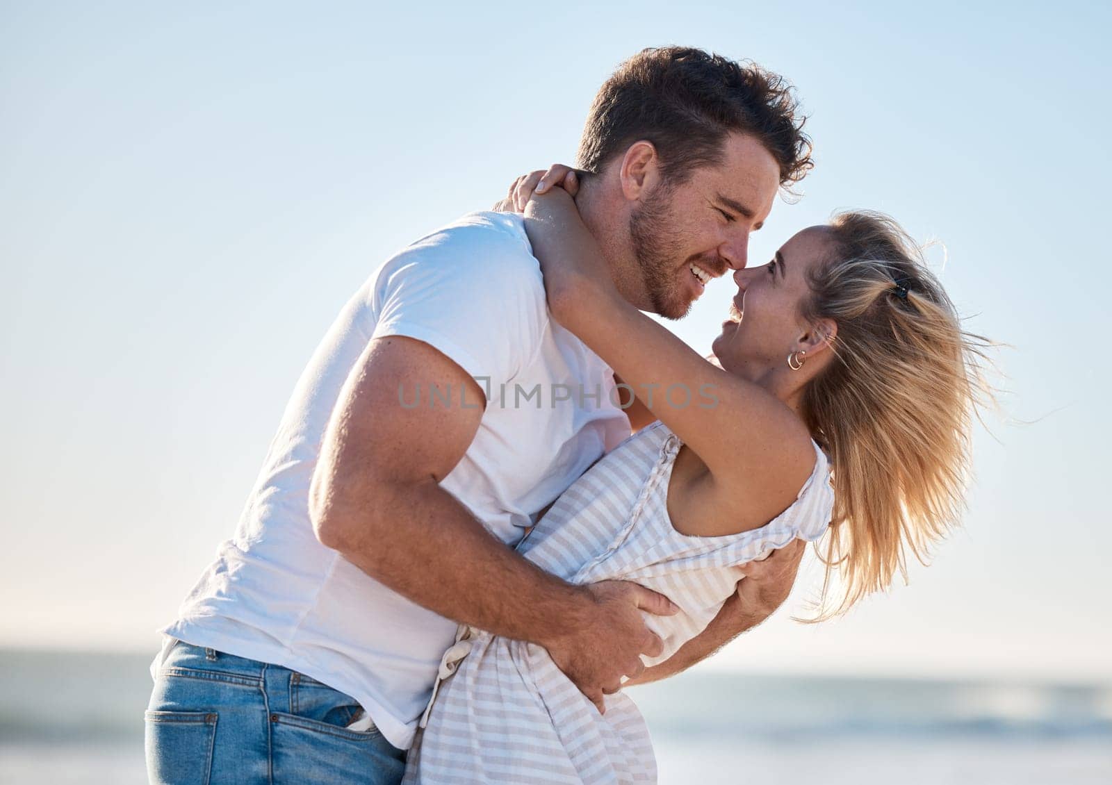 Couple, hug and love, happy at the beach with relationship and romance for bonding and together outdoor by the ocean. Romantic, care and travel date with man and woman hugging and quality time