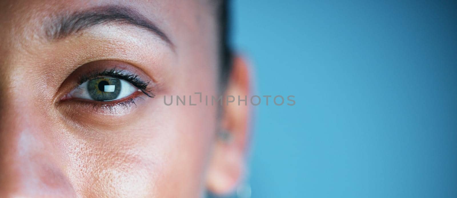 Eye, face and mockup with woman in portrait, vision and eye care with ophthalmology isolated on blue background. Eyebrow, future and perception, contact lens and lashes, awareness and focus in studio by YuriArcurs