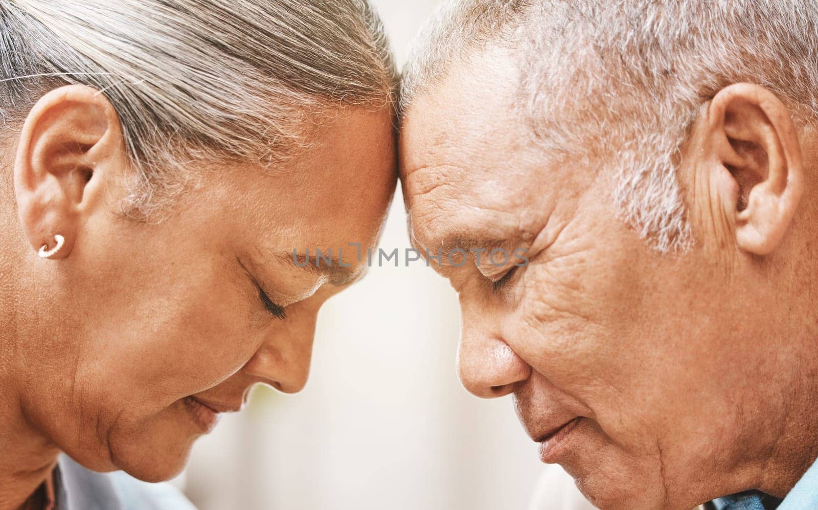 Face, love and support with a senior couple in their home, touching heads in trust or solidarity together. Relax, peace or romance with a mature man and woman bonding in their house during retirement.